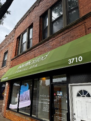 Clean green storefront awning on a brick building