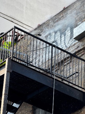 Black iron balcony railing above a wall being cleaned