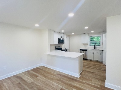 Remodeled kitchen with white cabinets and peninsula