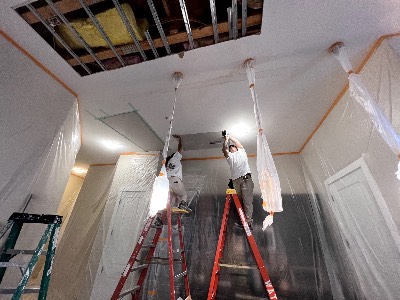 Crew repairing a ceiling with dust containment
