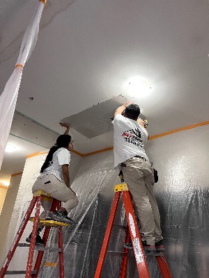 Technicians finishing a ceiling repair