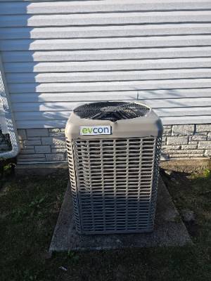 Lennox air conditioner condenser installed on a slab beside a home