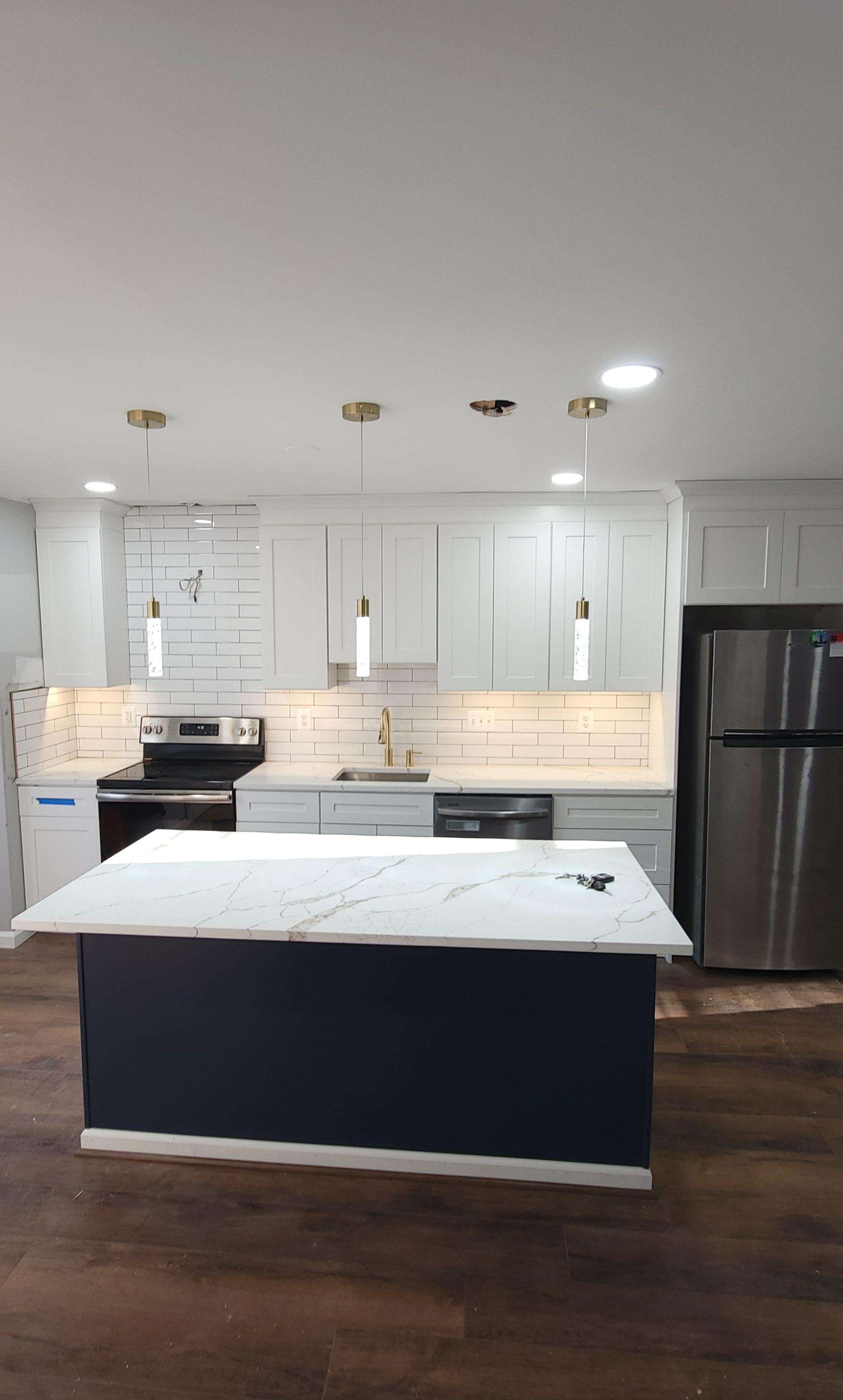White kitchen remodel with a navy island and new flooring by 4 Way Construction in Manassas, VA