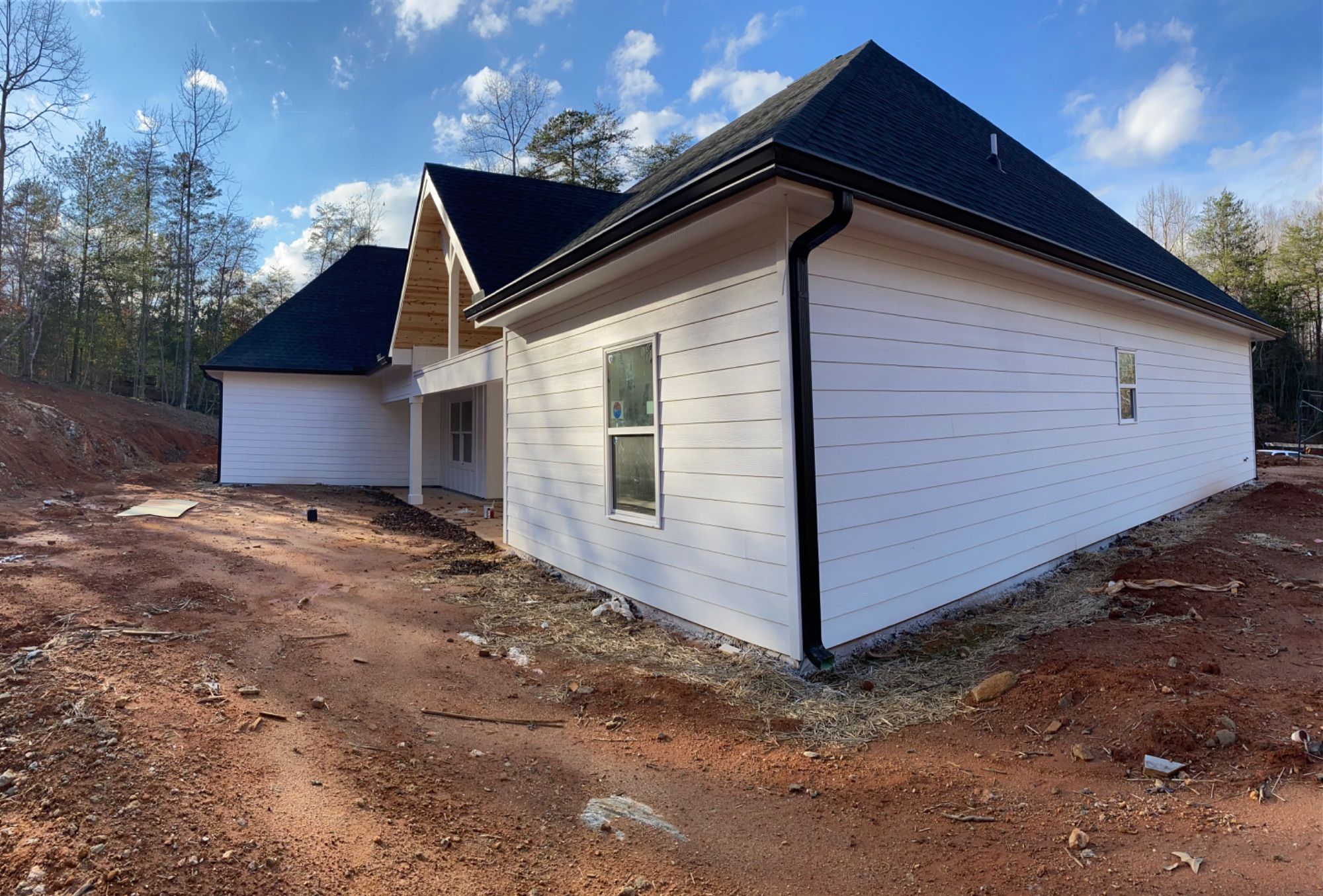 A house finished in white by Jireh Painting and Remodeling under a clear sky