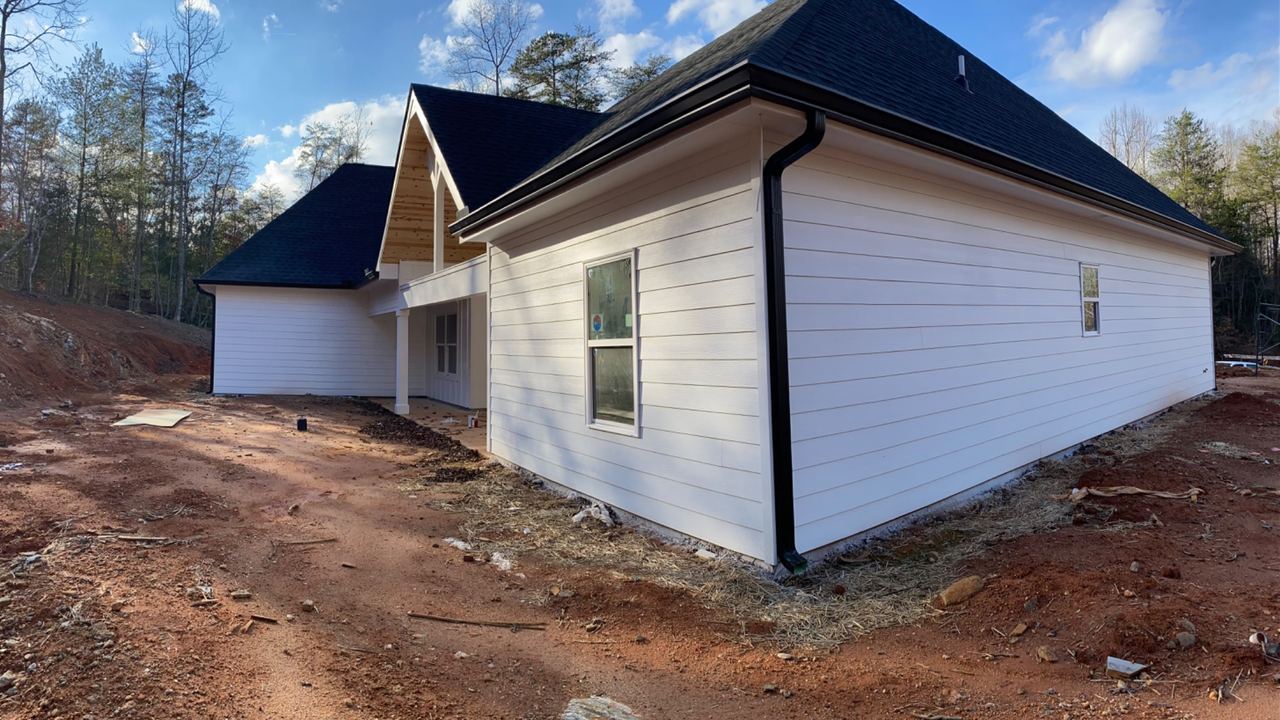 A house finished in white by Jireh Painting and Remodeling under a clear sky