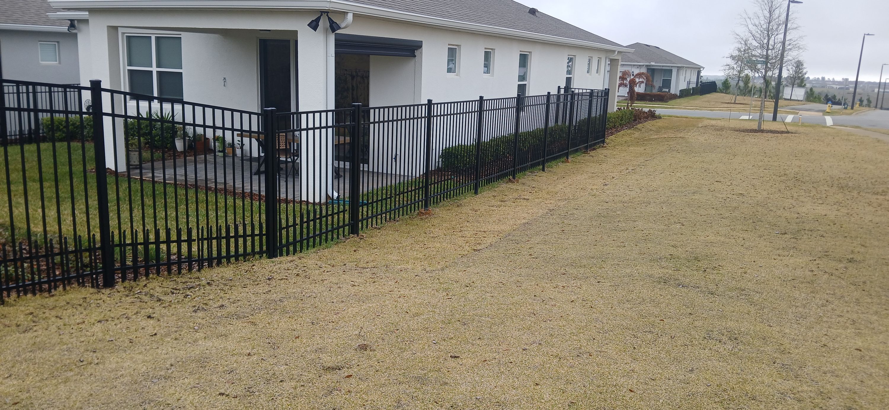 A black aluminium fence run installed by Marquez Yera Fence along a street of Orlando houses