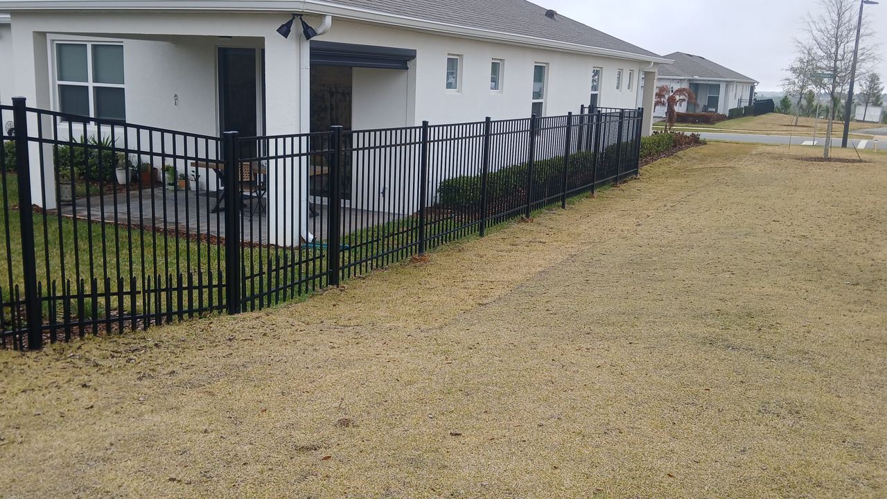 A black aluminium fence run installed by Marquez Yera Fence along a street of Orlando houses