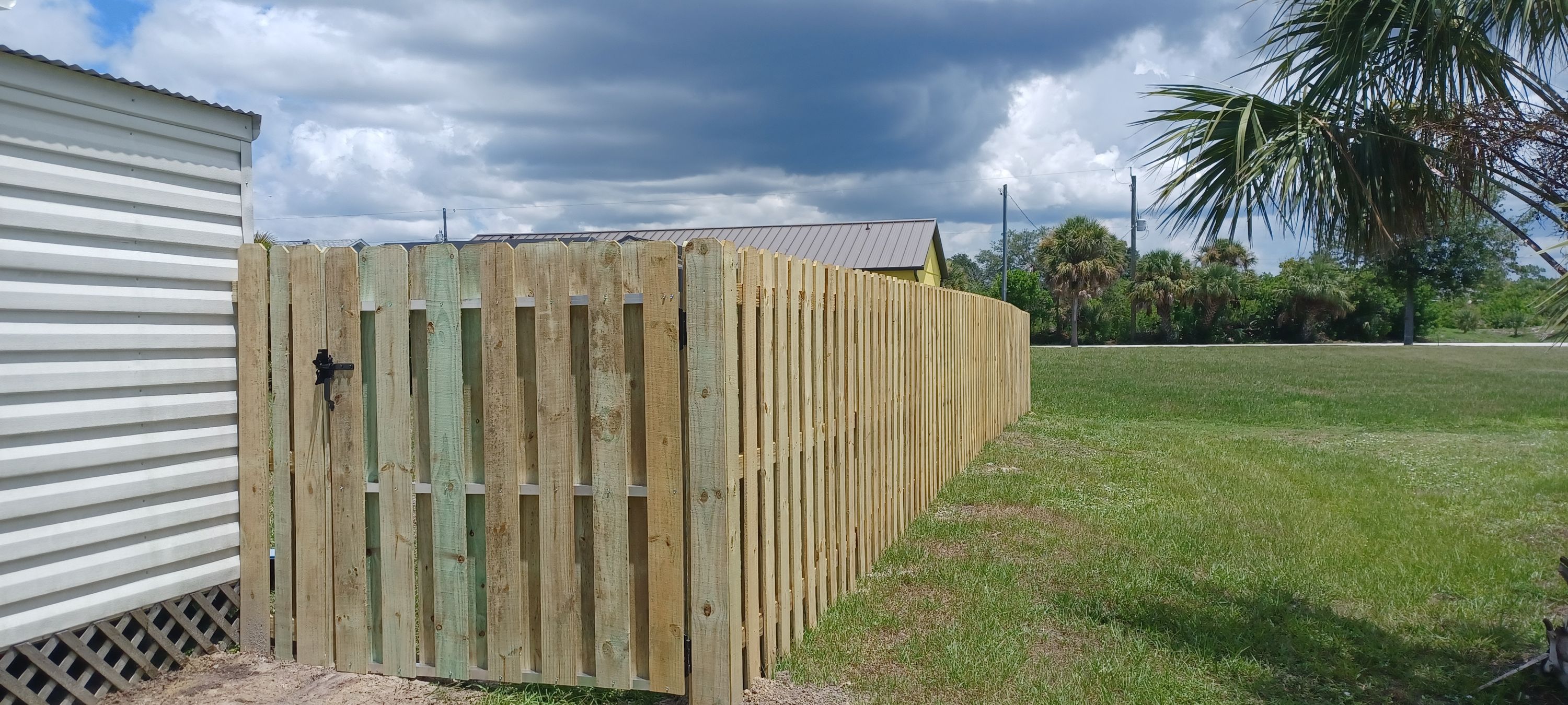 A wood shadowbox fence and gate built by Marquez Yera Fence under an open Florida sky