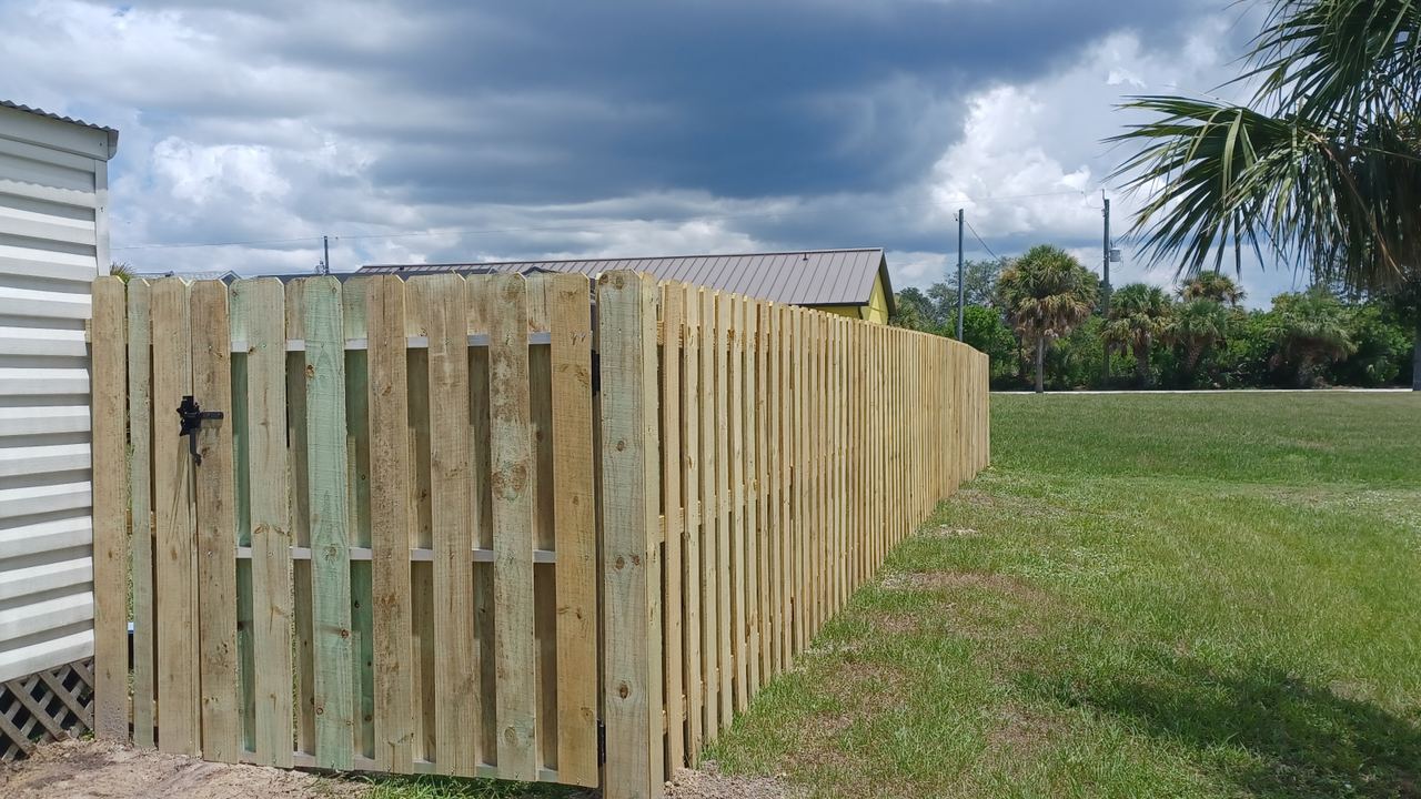 A wood shadowbox fence and gate built by Marquez Yera Fence under an open Florida sky