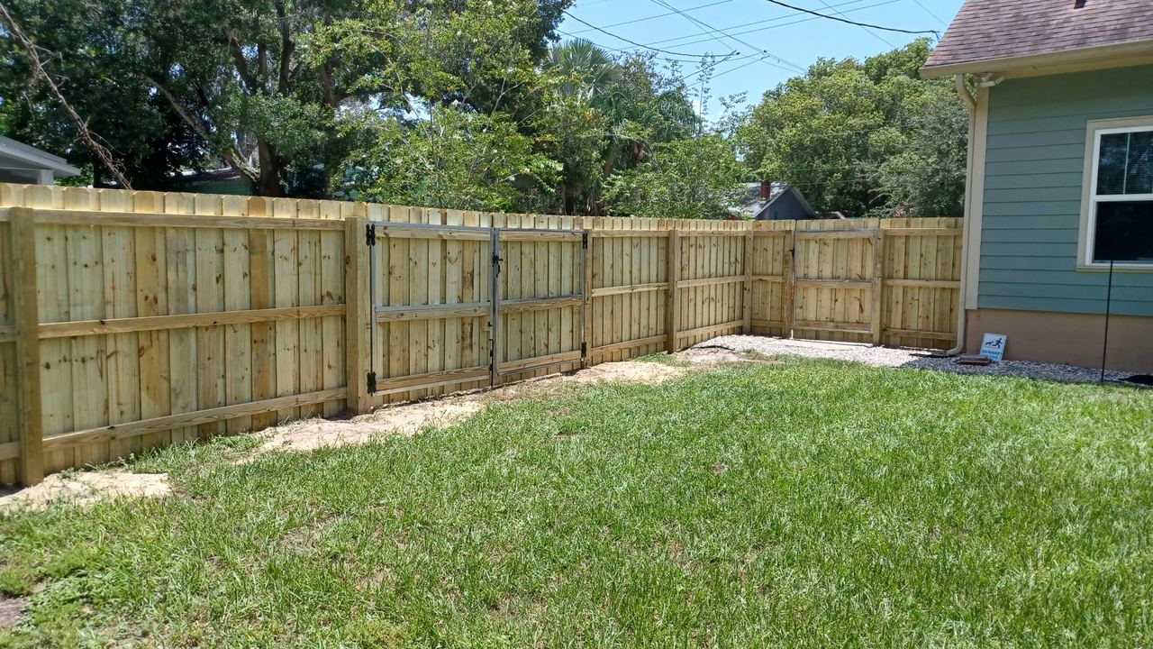 A wood privacy fence installed by Marquez Yera Fence along a green Orlando back yard