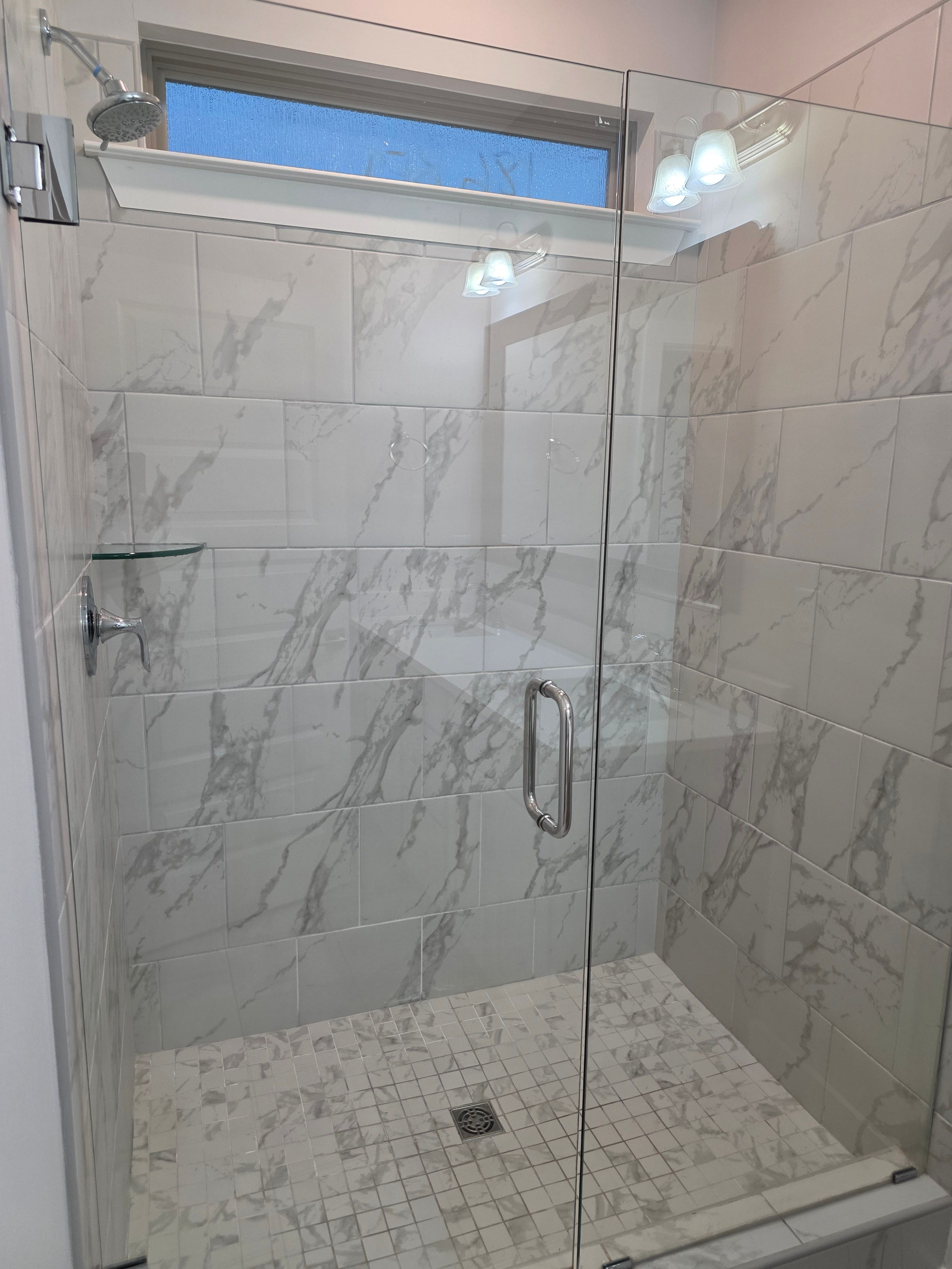 Scrubbed marble tile shower with streak-free glass cleaned by Sandra House Cleaning Service in Huntsville, AL