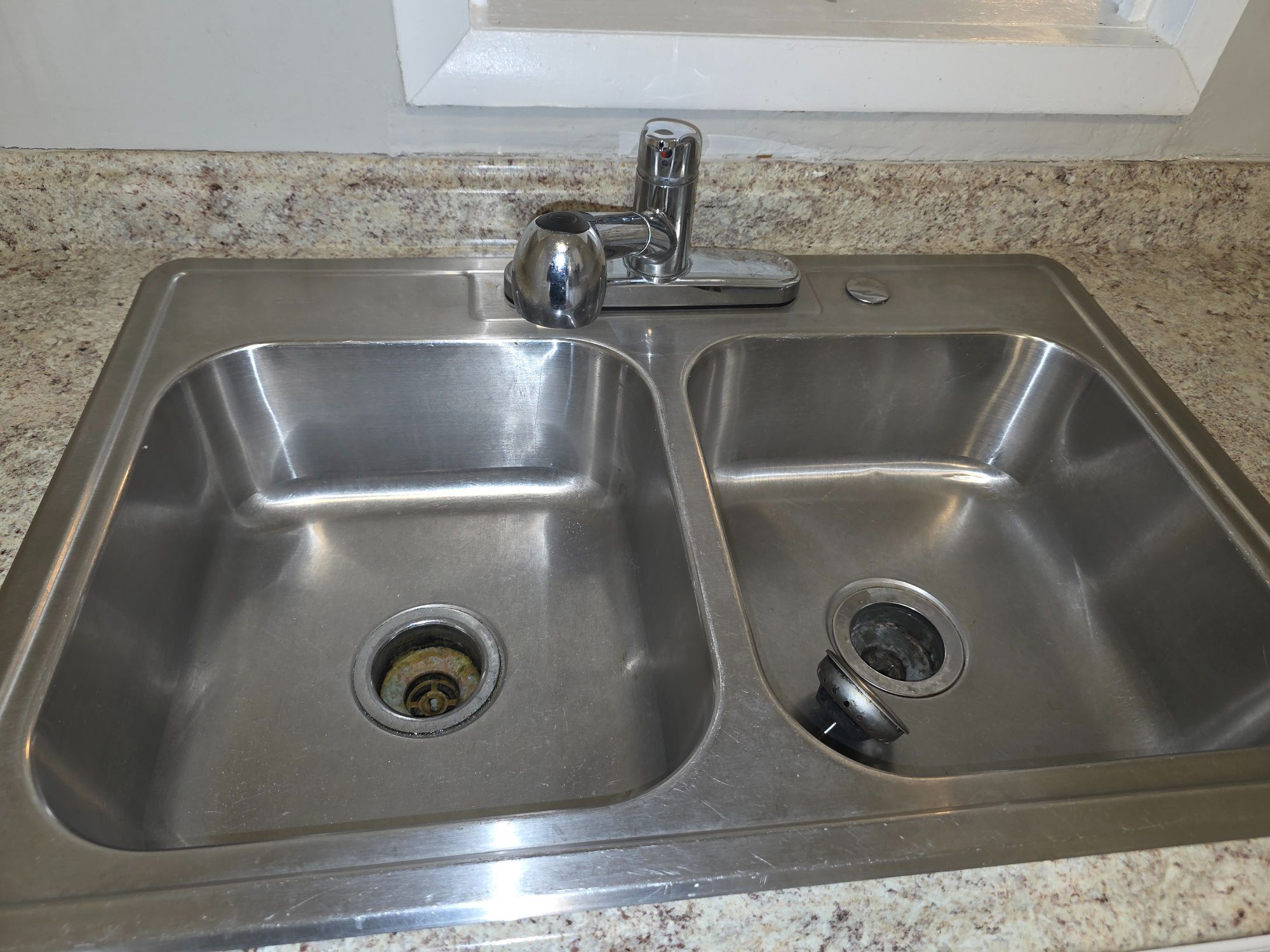 Polished stainless steel kitchen sink cleaned by Sandra House Cleaning Service in Huntsville, AL