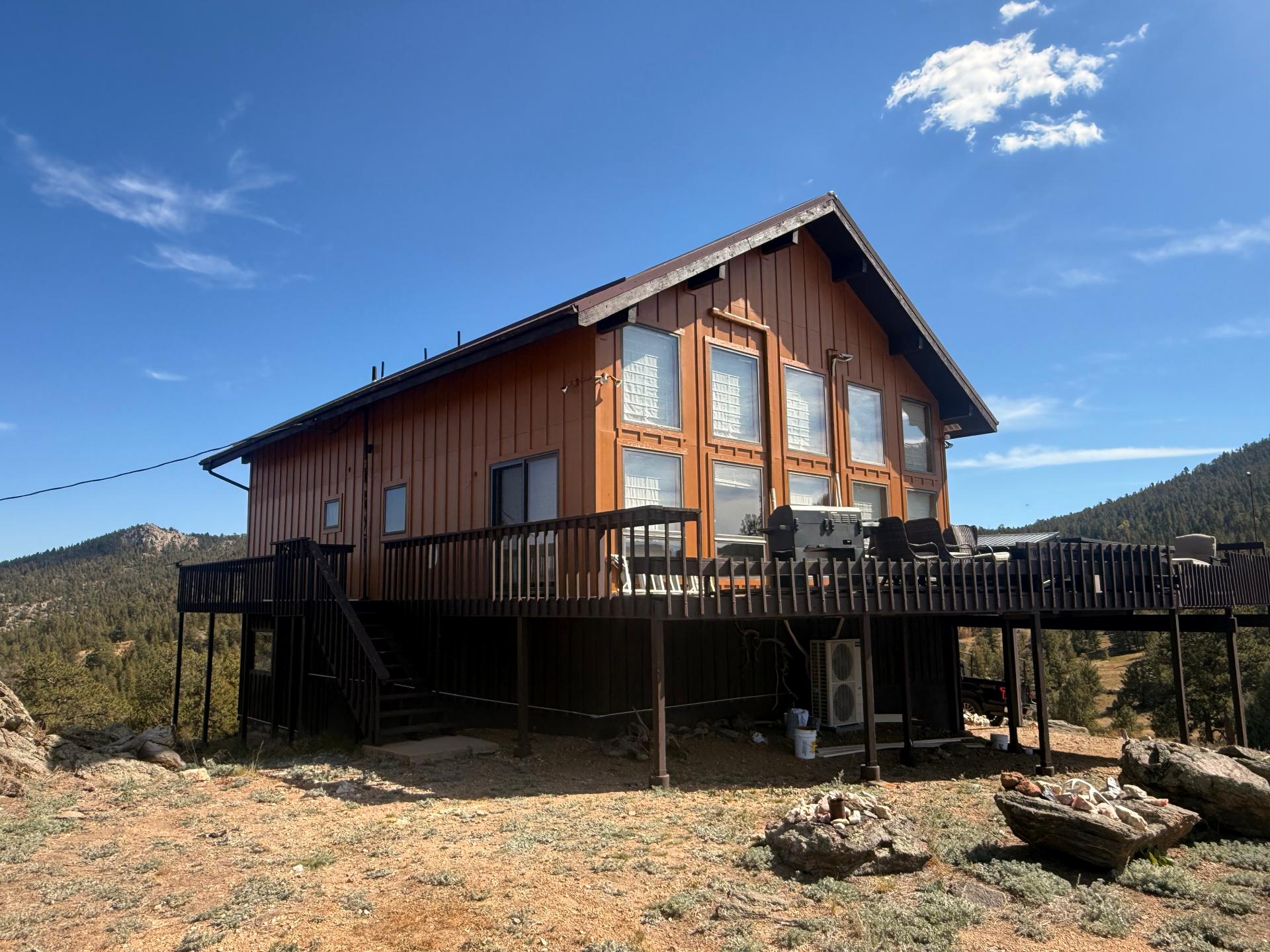 Mountain home with freshly stained siding and deck, finished by A&C Painting LLC