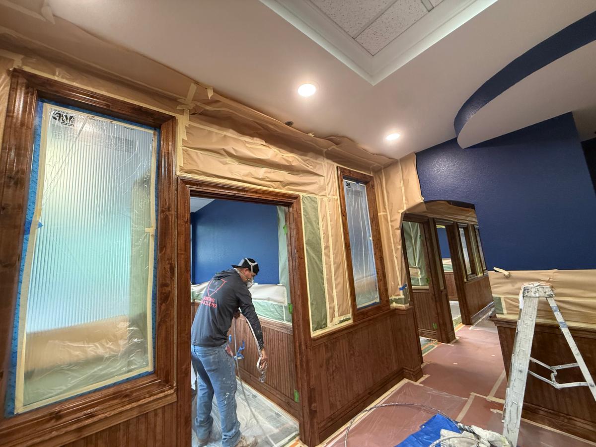 A&C Painting crew finishing interior window trim and wood paneling