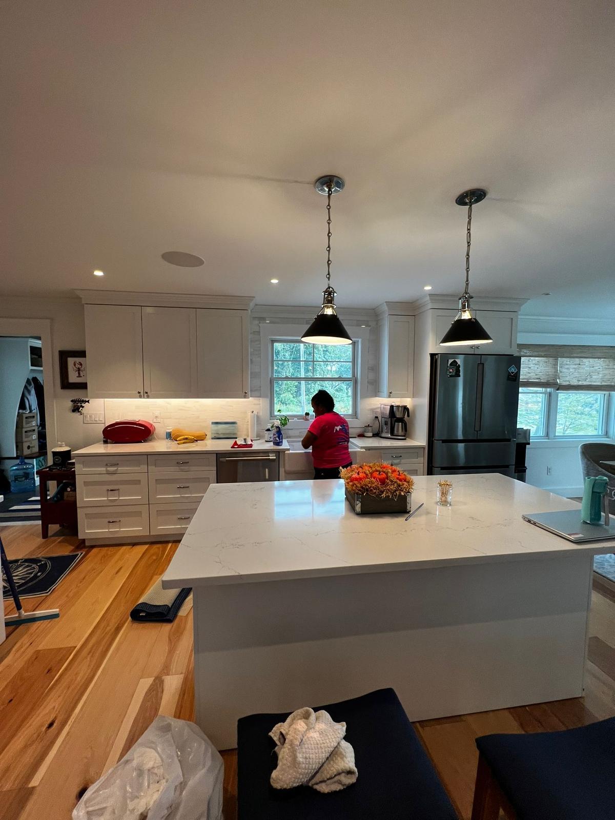 An América Braga Cleaning team member wiping down a kitchen island in a client's home