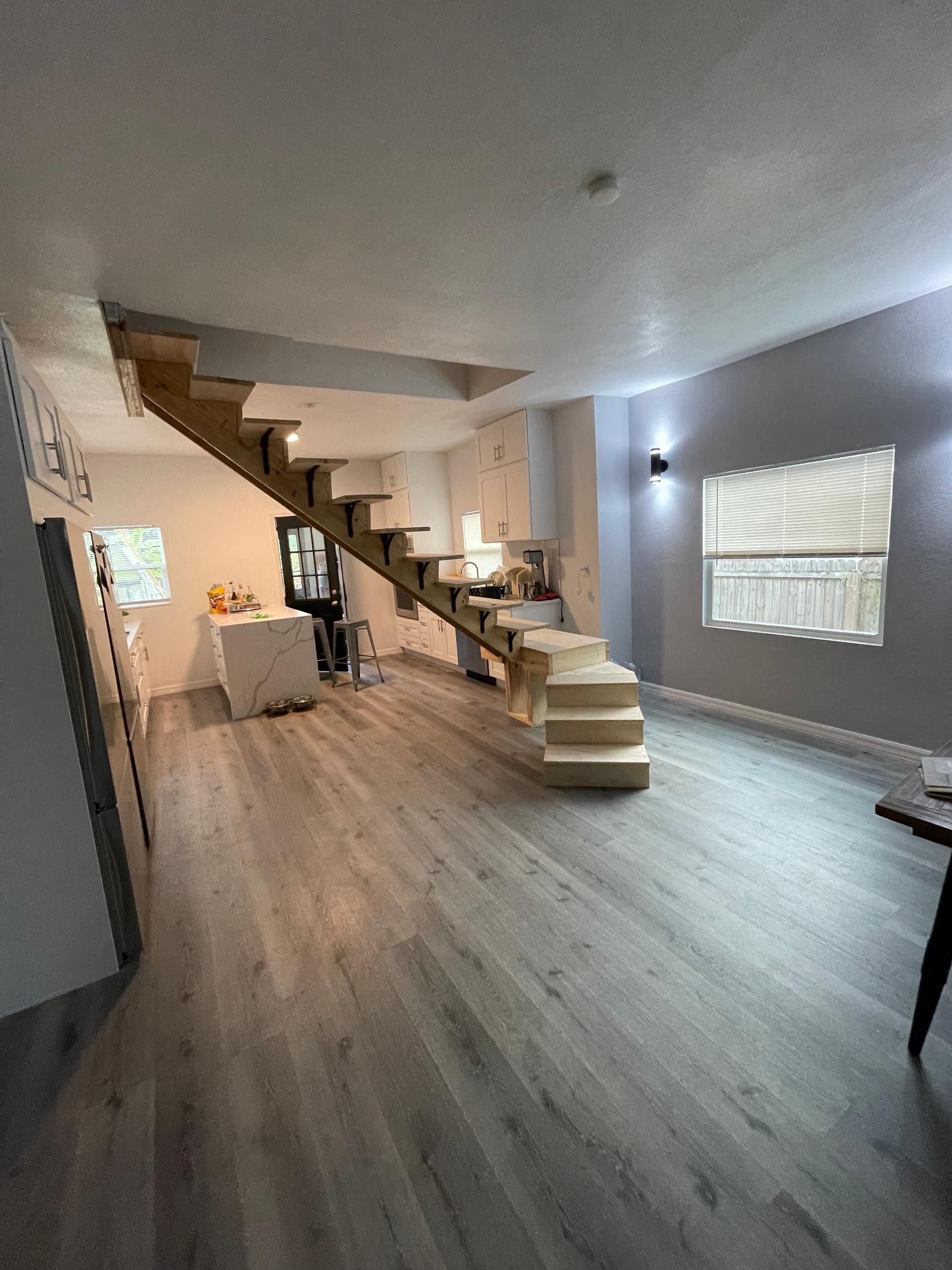 Open-plan living space and new stairs built by American AJ Remodeling & Construction