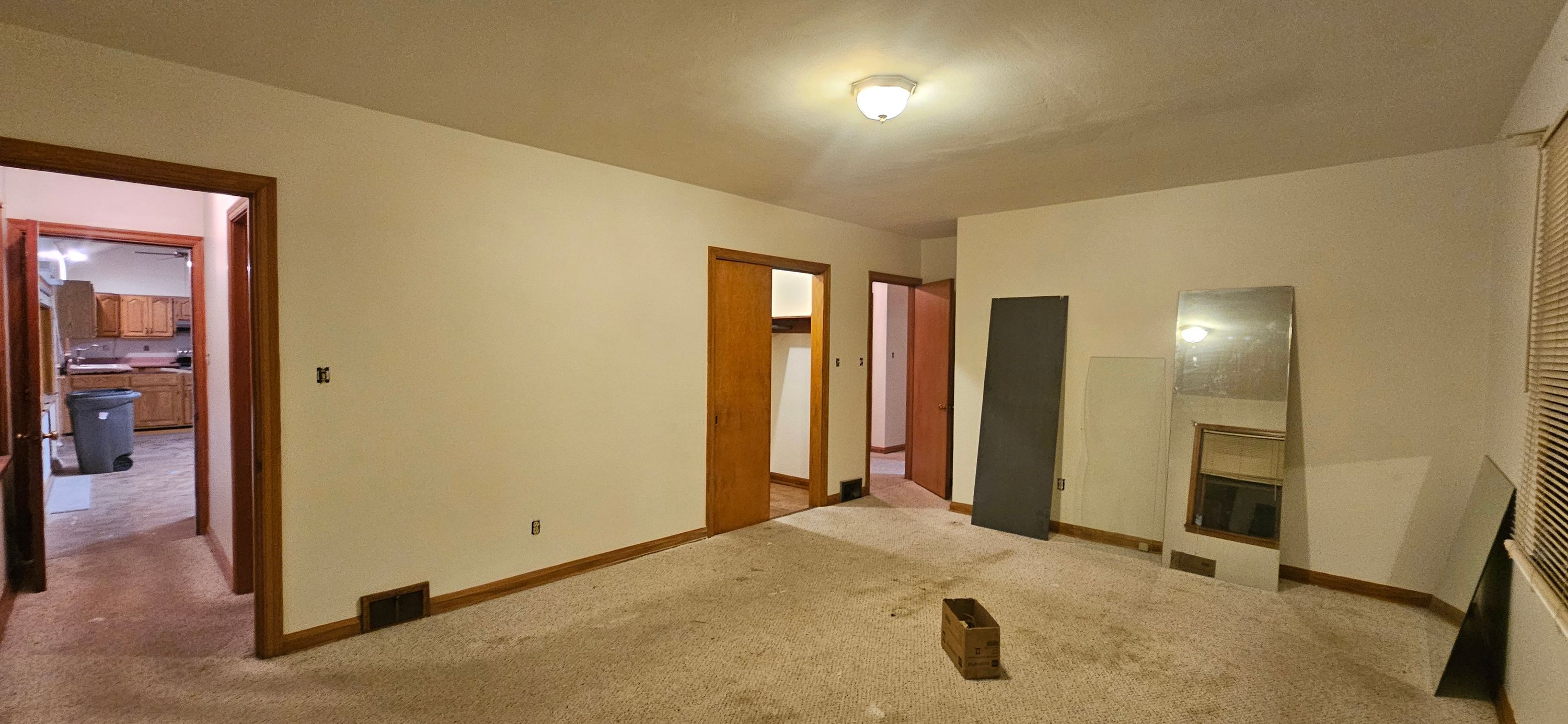 The same bedroom finished in uniform cream with wood trim and open doorways