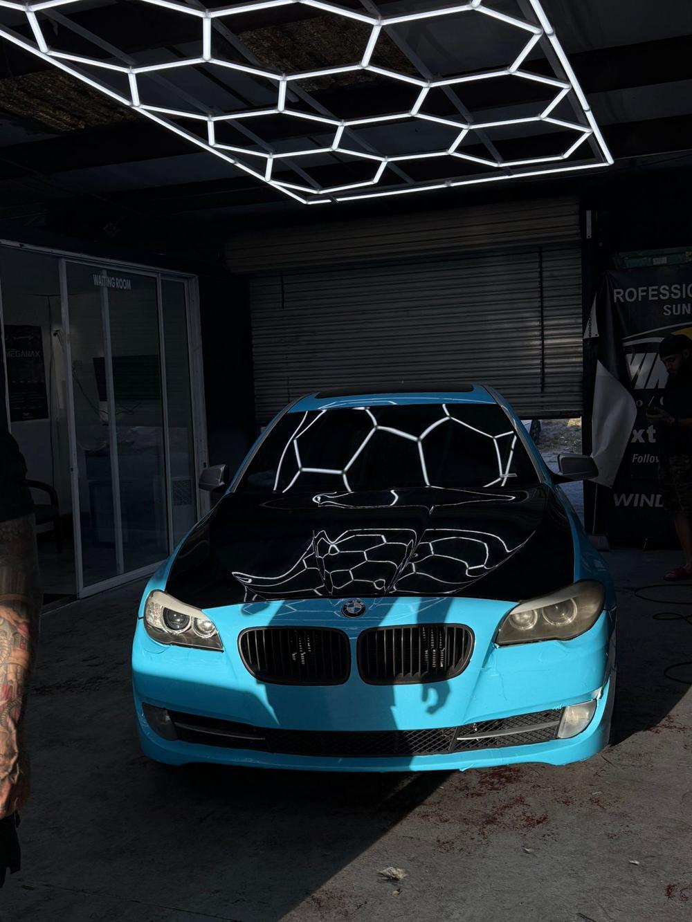 Car inside the Bris Window Tint install bay under hexagon shop lighting