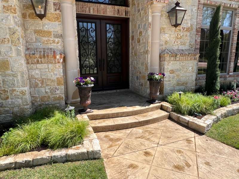 Stone entry, stamped concrete and planted beds completed by Castle Lawncare & Landscaping LLC