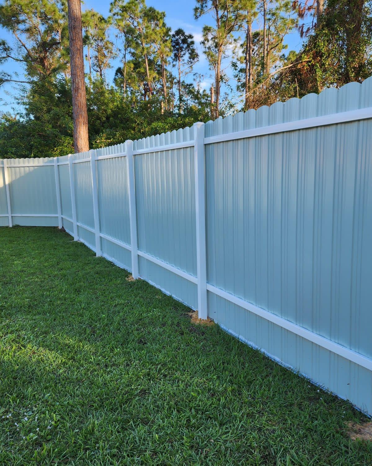 Long run of white vinyl privacy fence on a Southwest Florida lawn, installed by Cid Fence