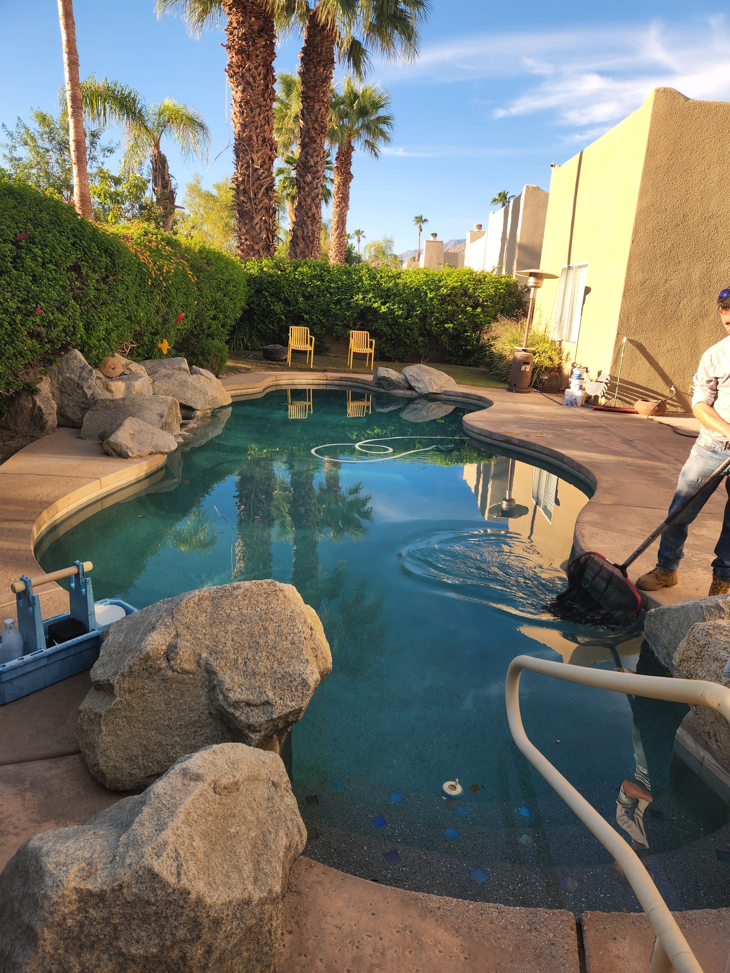 Freeform rock swimming pool being cleaned by Clear Waters Pool Service in Palm Springs, CA
