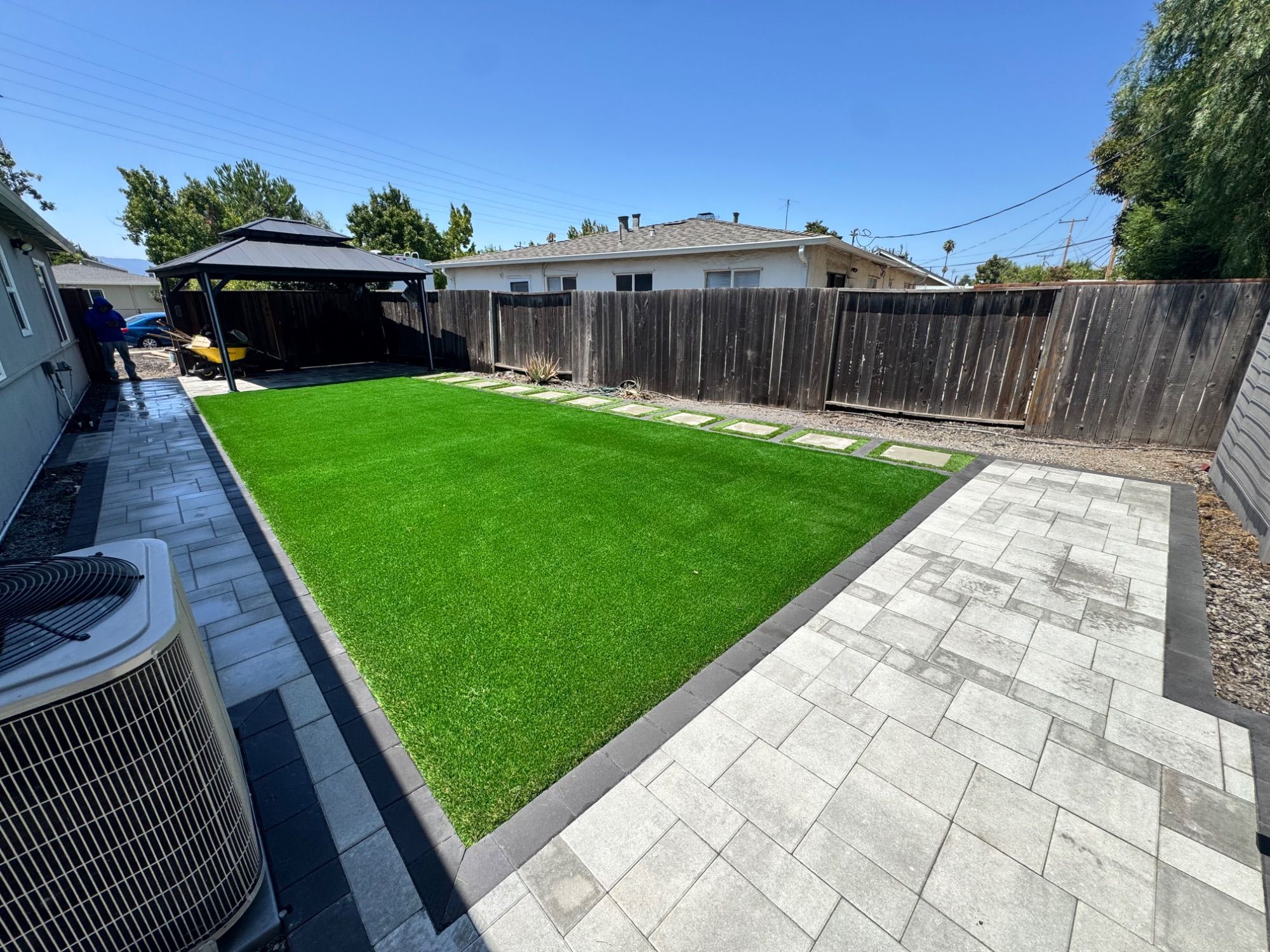 Backyard turf with a paver walkway and stepping pads