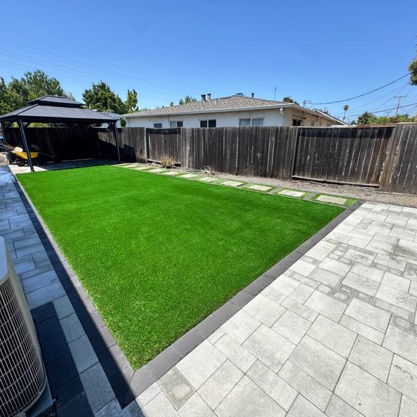 Backyard turf with a paver walkway and stepping pads