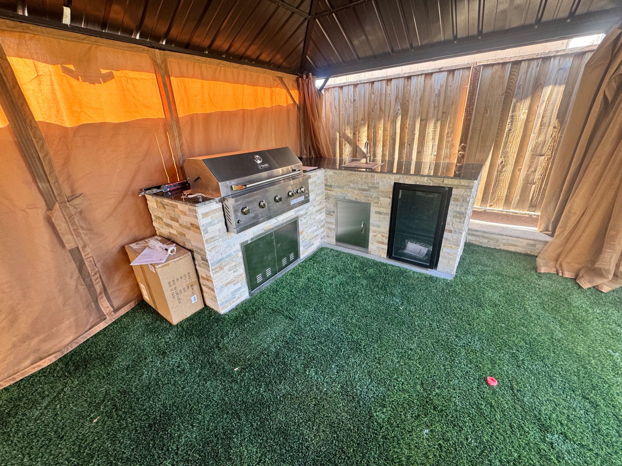 Covered outdoor kitchen with turf underfoot