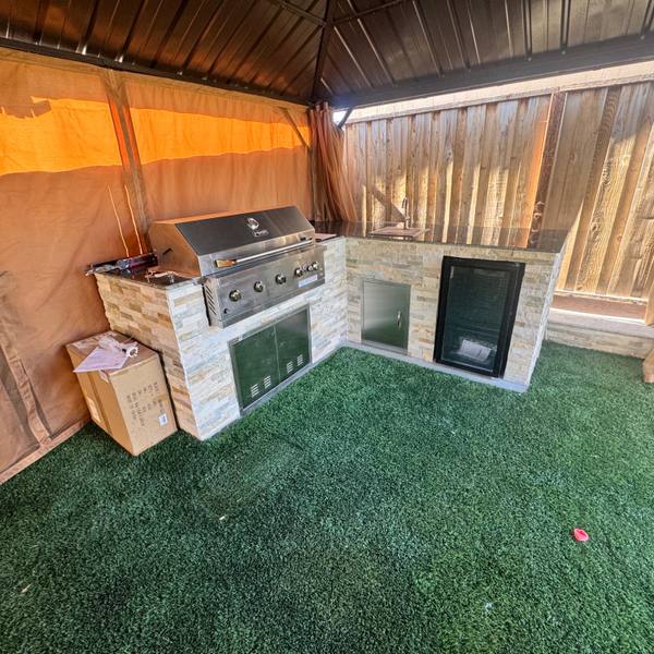Covered outdoor kitchen with turf underfoot