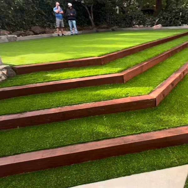 Terraced artificial turf with timber edging and concrete pads
