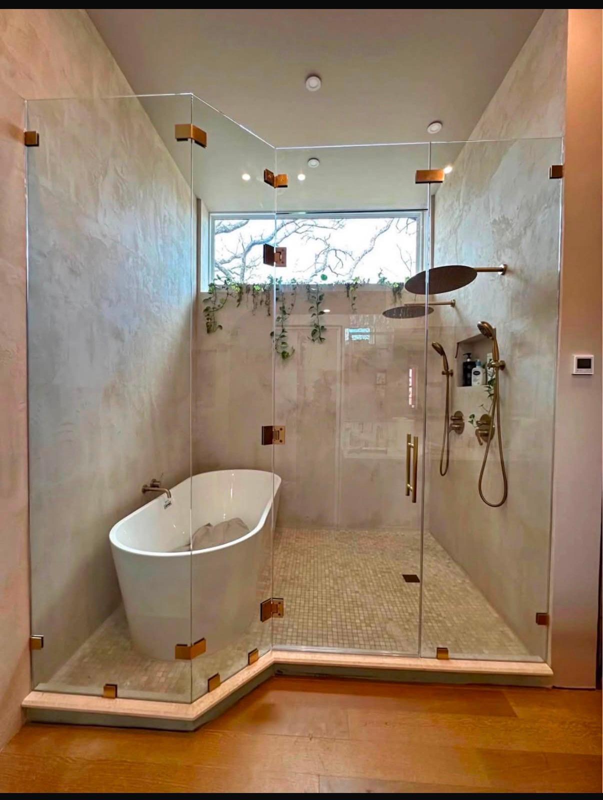 Frameless glass enclosure around a freestanding tub and walk-in shower, installed by Colina's Remodeling Service Co