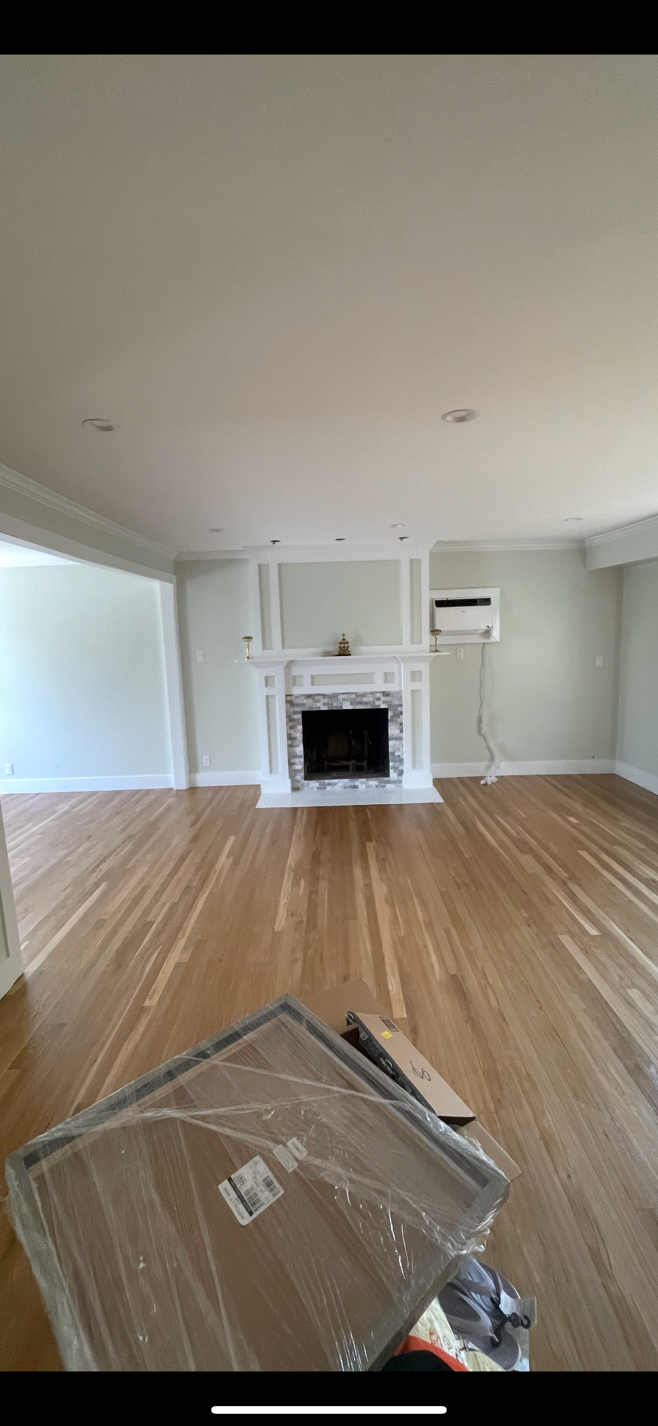 Living room with a white painted fireplace mantel, fresh walls and hardwood flooring — FE Pro Painting