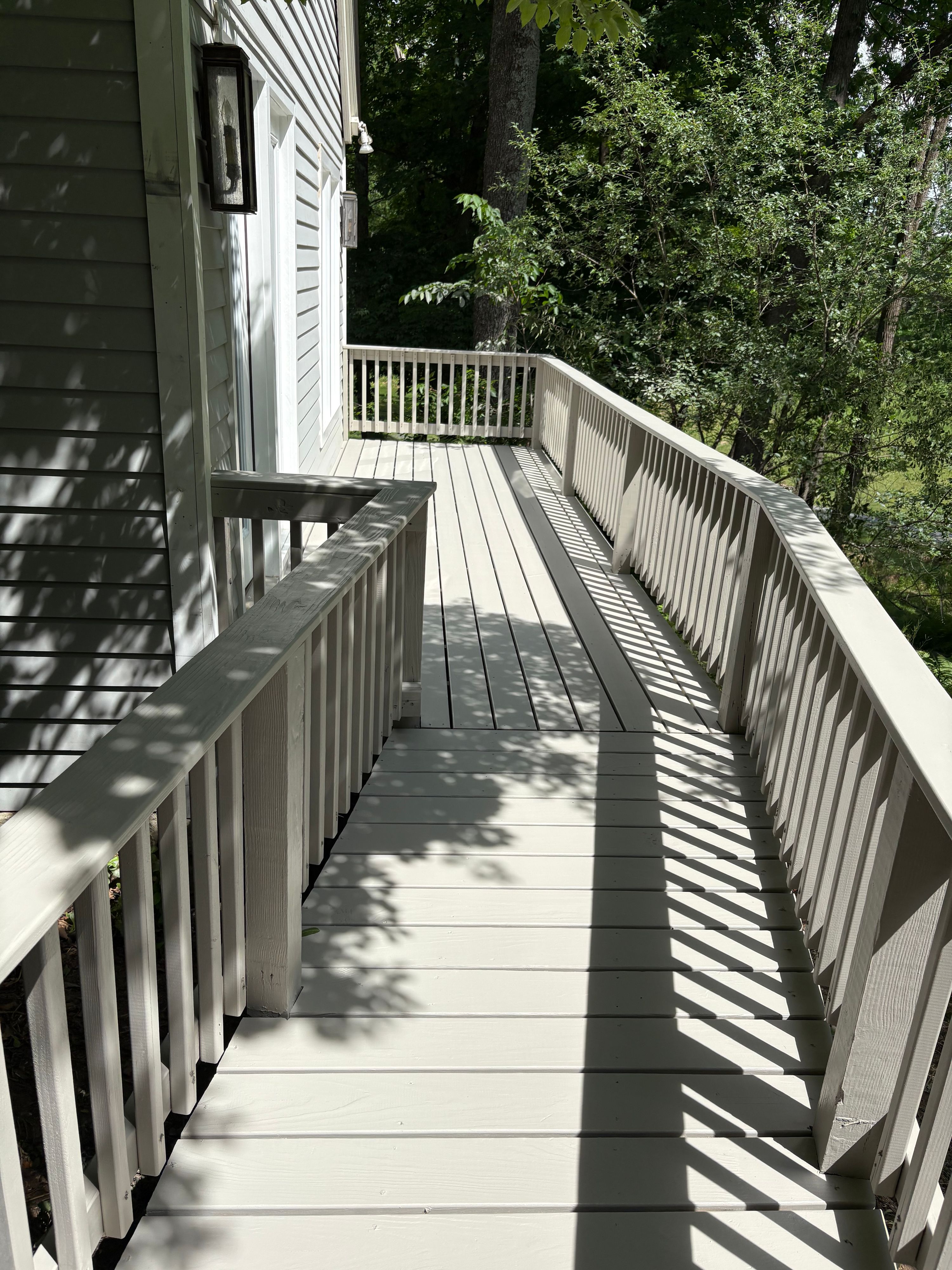 Exterior deck and access ramp with grey-painted decking and white railings — FE Pro Painting