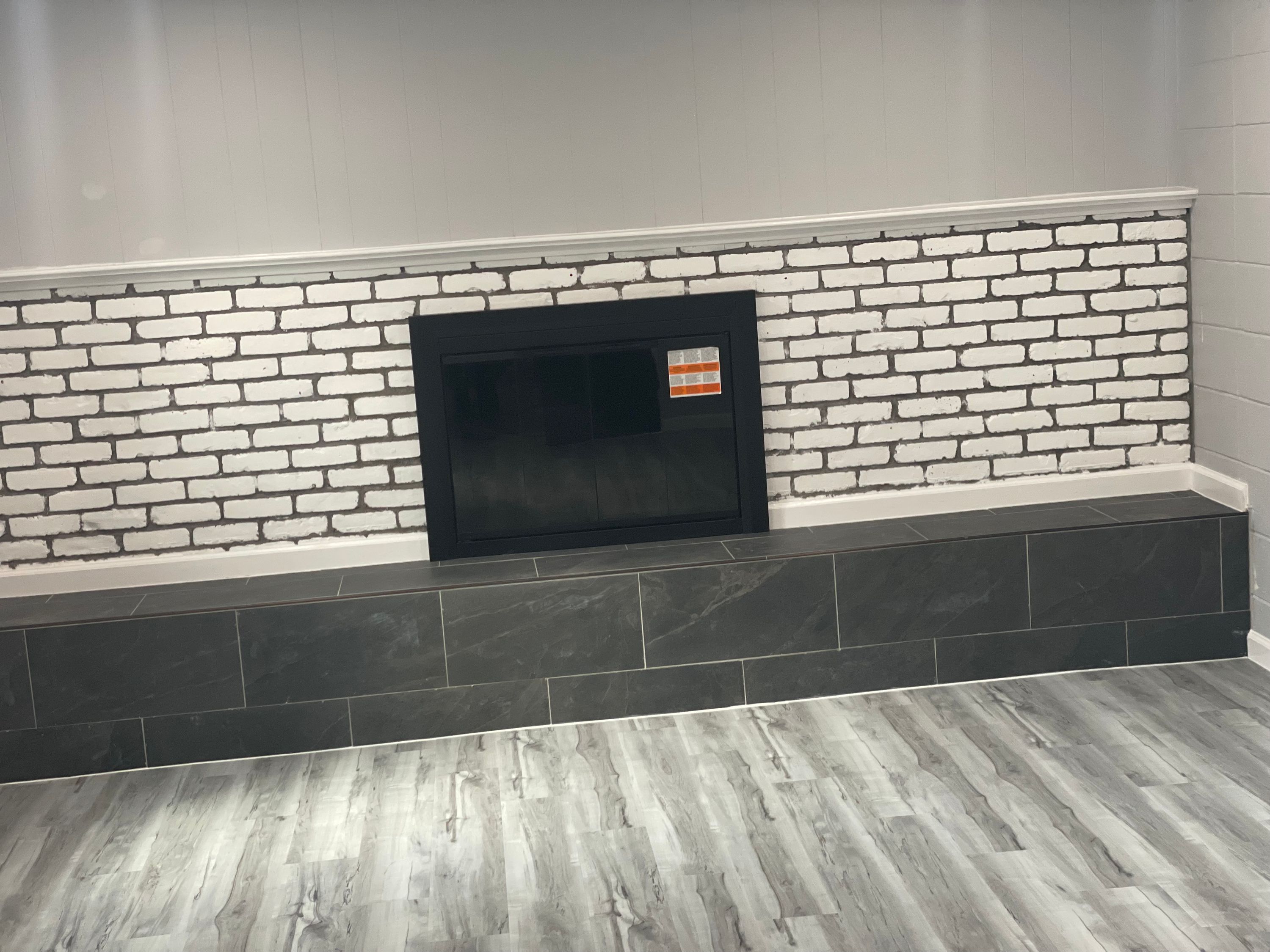 Feature wall in white brick with a dark tiled lower band and a recessed niche — FE Pro Painting