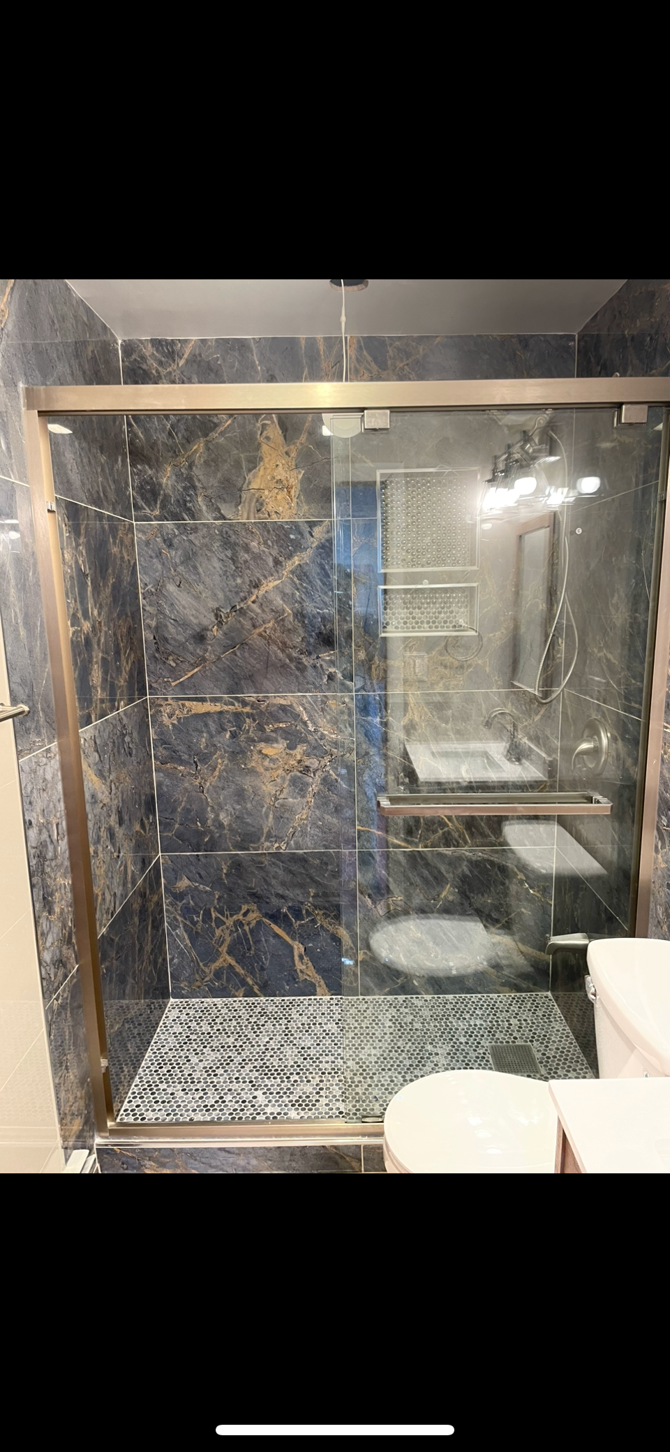 Walk-in shower finished in large dark marble-effect tile with a mosaic floor — FE Pro Painting