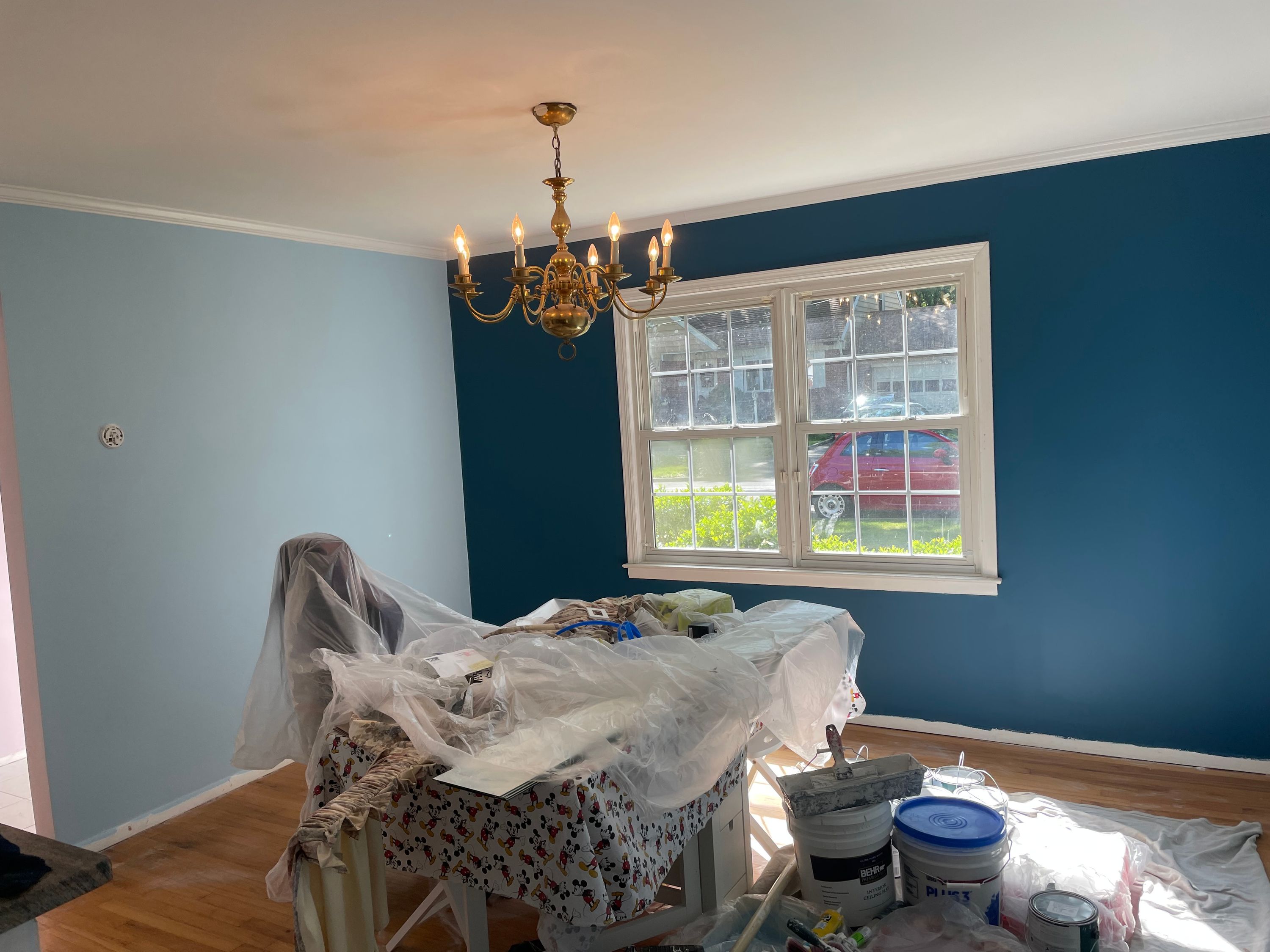 Dining room painted a deep teal, furniture sheeted and floors protected mid-job — FE Pro Painting