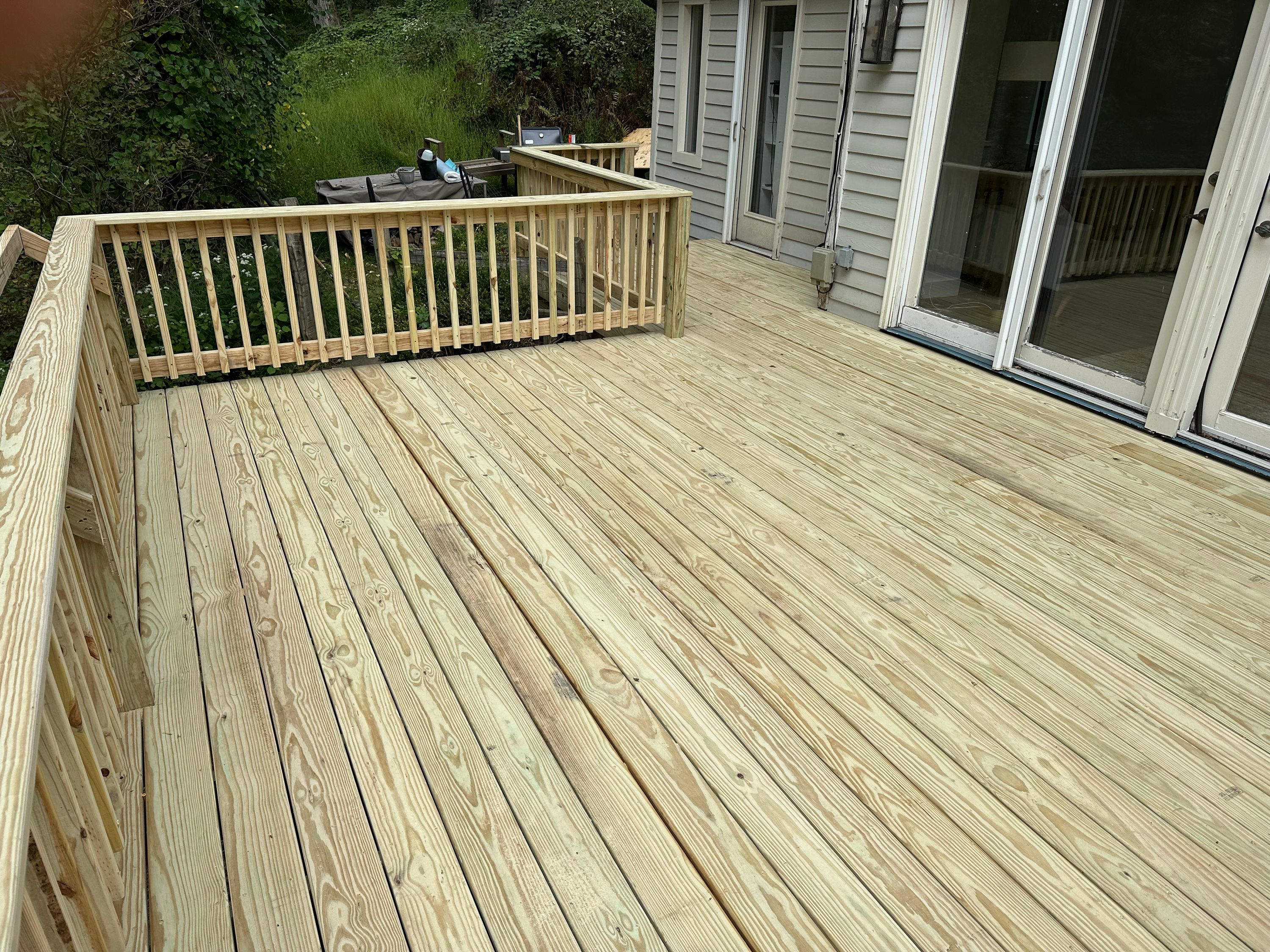 Newly built pressure-treated timber deck running along the back of a house — FE Pro Painting
