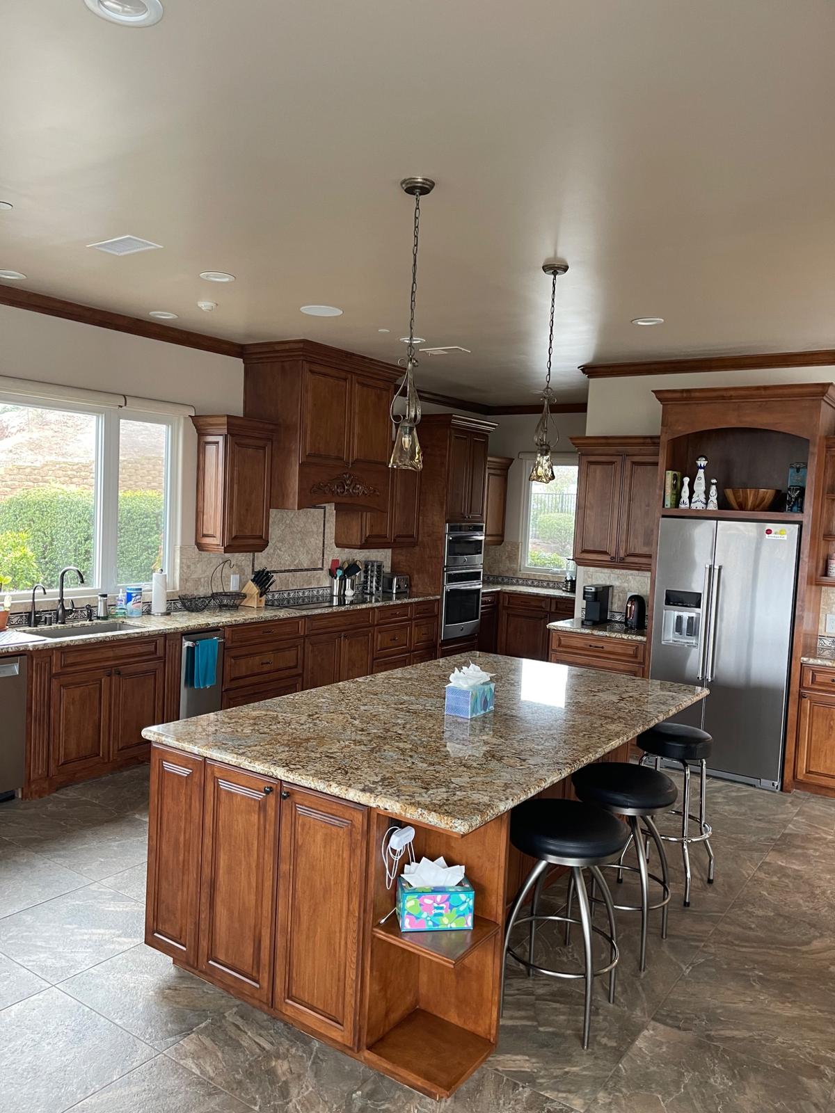 Kitchen with polished granite island and wiped-down cabinets after a clean