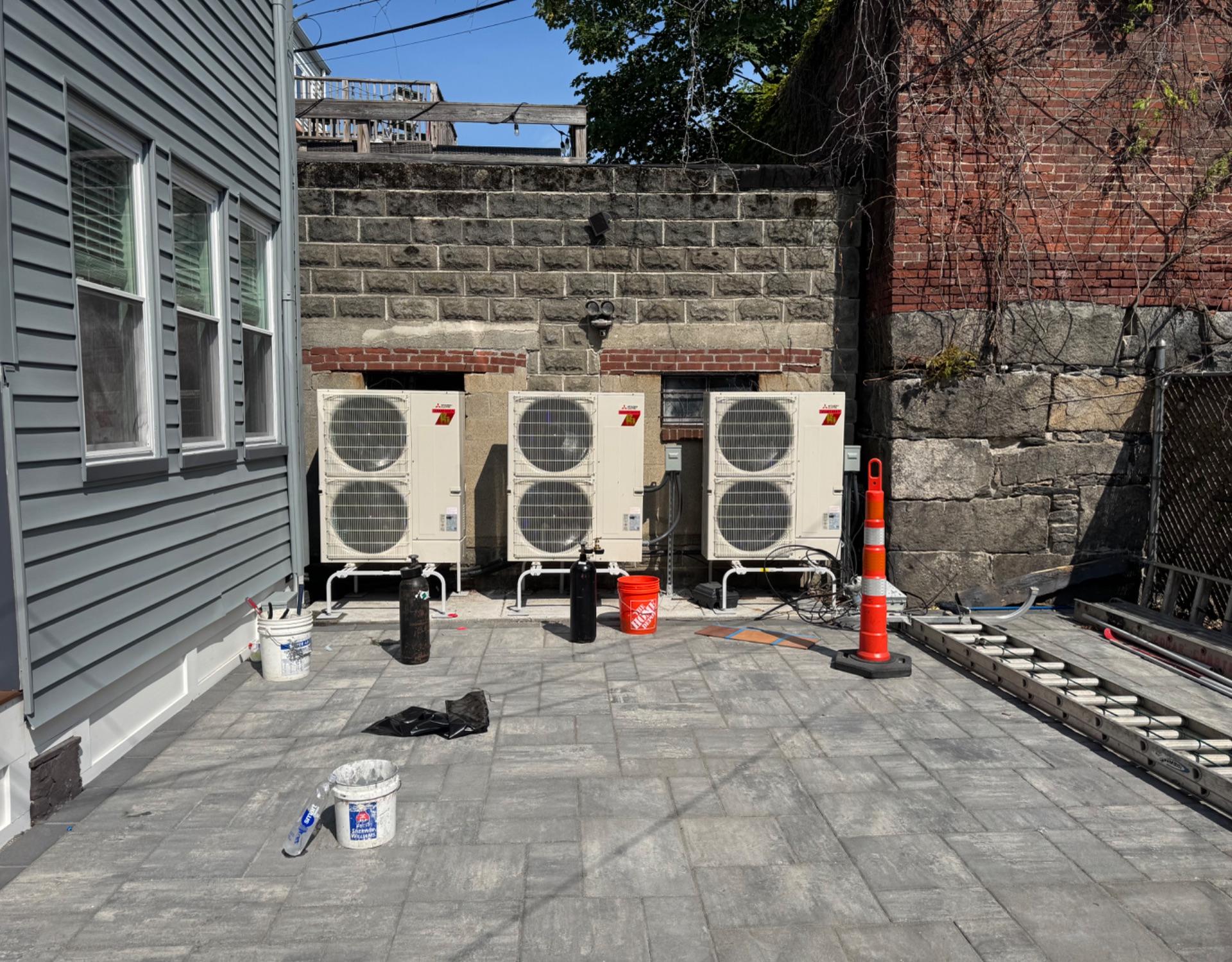 Three multi-zone heat pump condensers installed by Garcia Services HVAC on a Somerville patio
