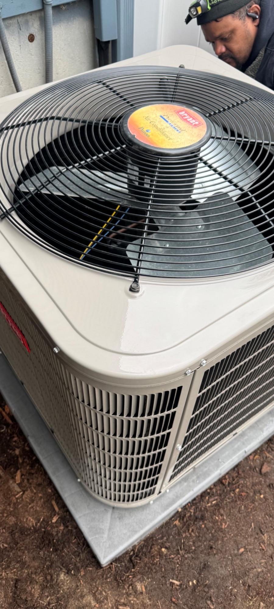 Garcia Services HVAC technician servicing an outdoor condenser beside a home