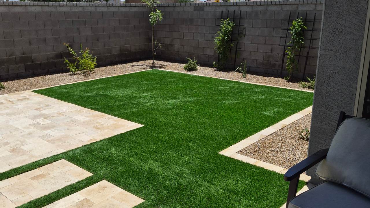 Completed backyard by German LLC — synthetic grass, travertine walkway and new desert plantings in Phoenix, AZ