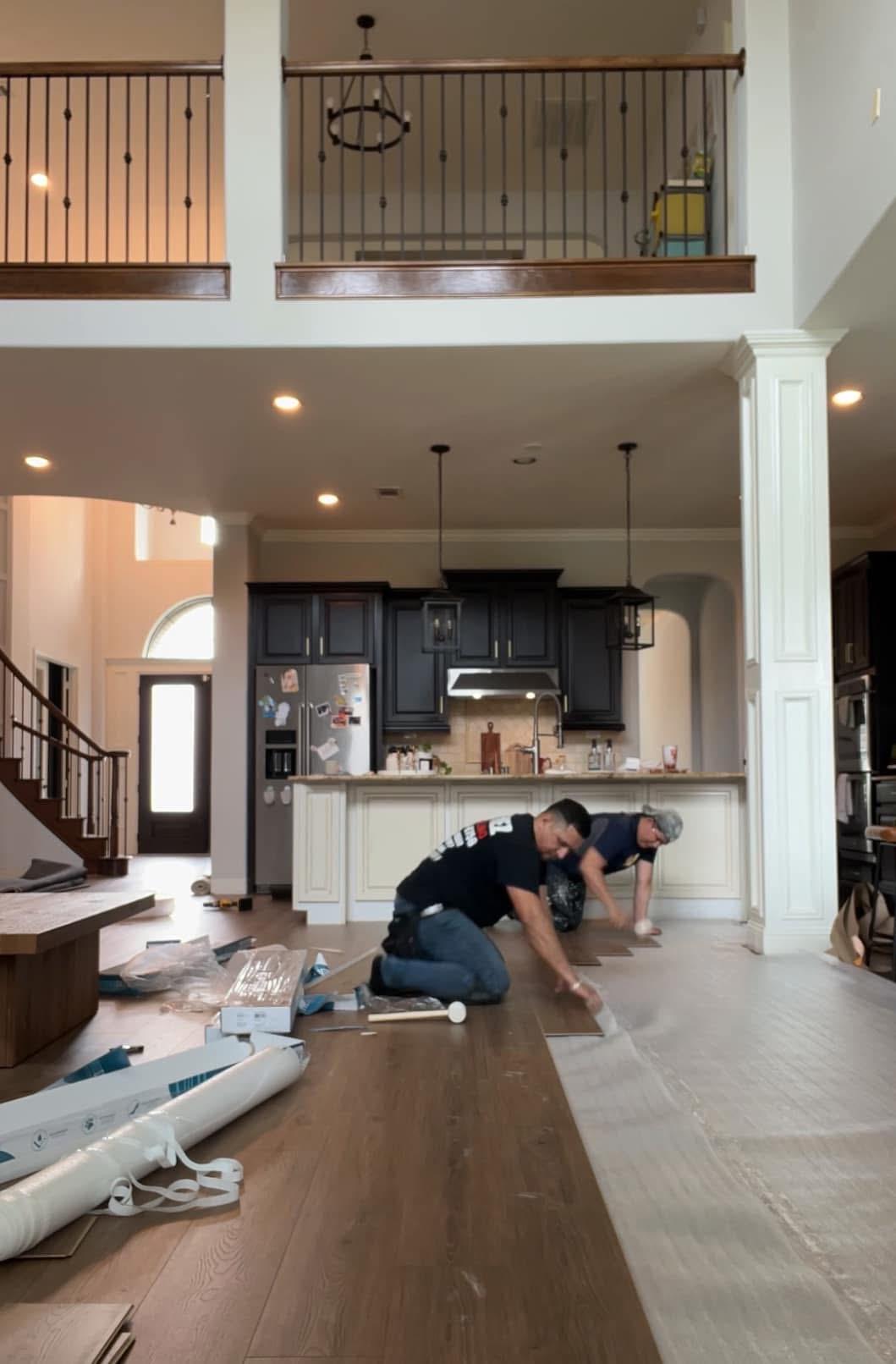 Reformas integrales VIR crew installing wood-look plank flooring in a Miami kitchen