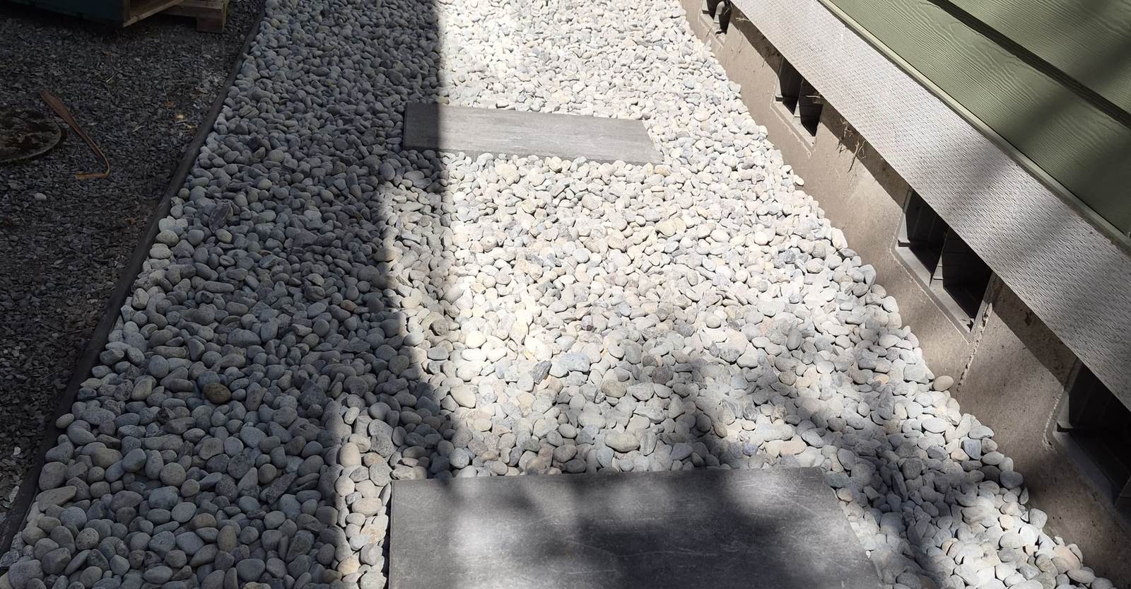 A gravel side-yard path set with stepping pavers, built by Goodfellas Landscape