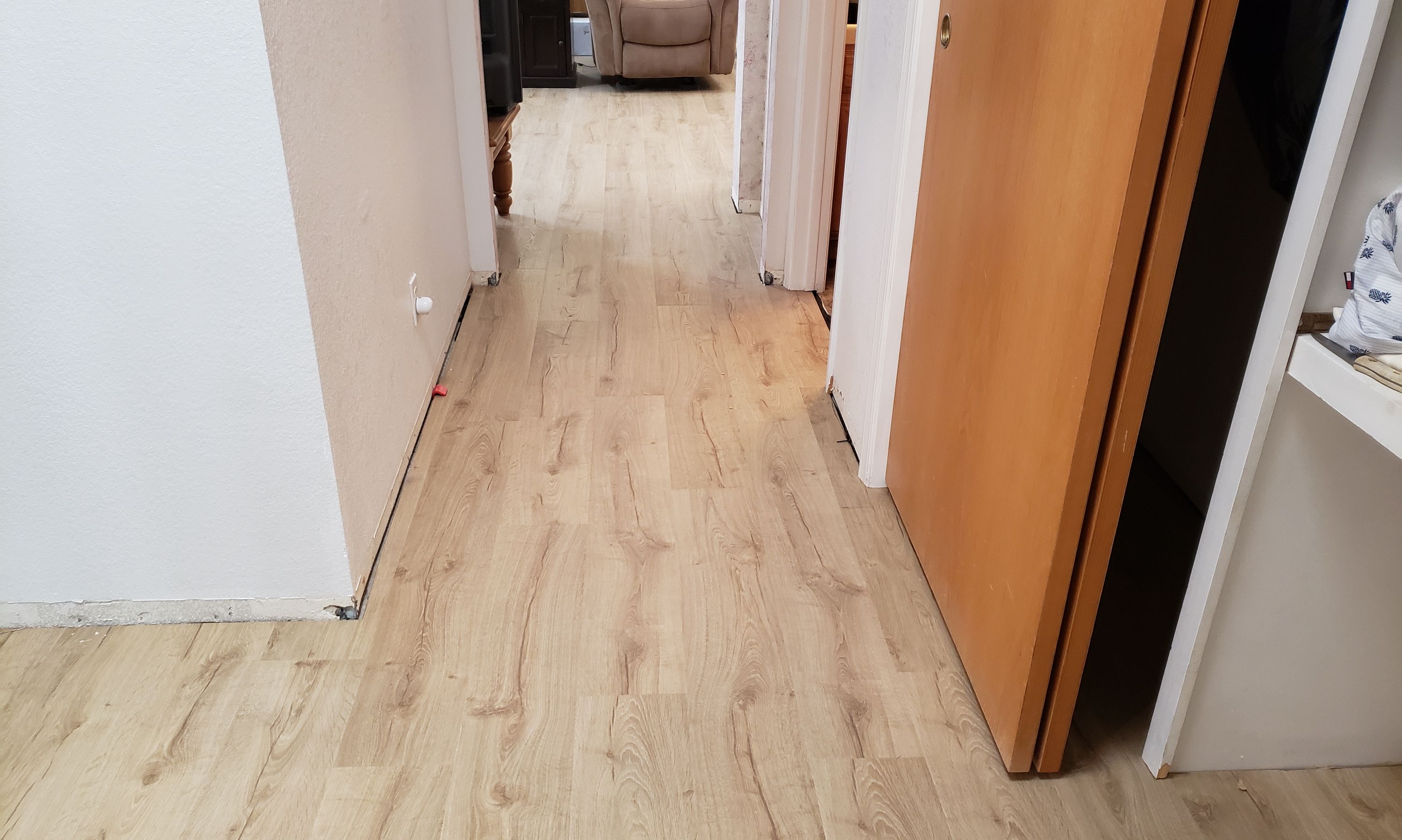Warm oak plank flooring running down a hallway, installed by Heavenly Floors, Inc.
