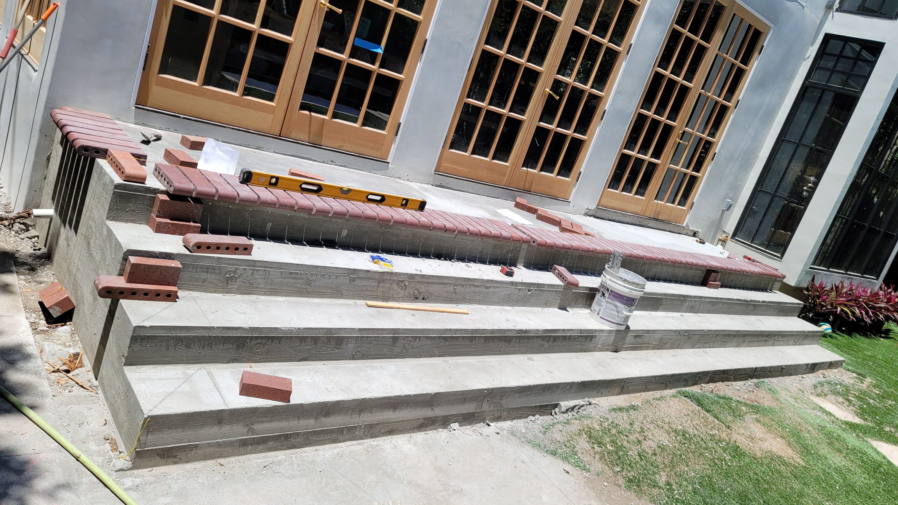 Brick landing being laid, with a level and stacked brick