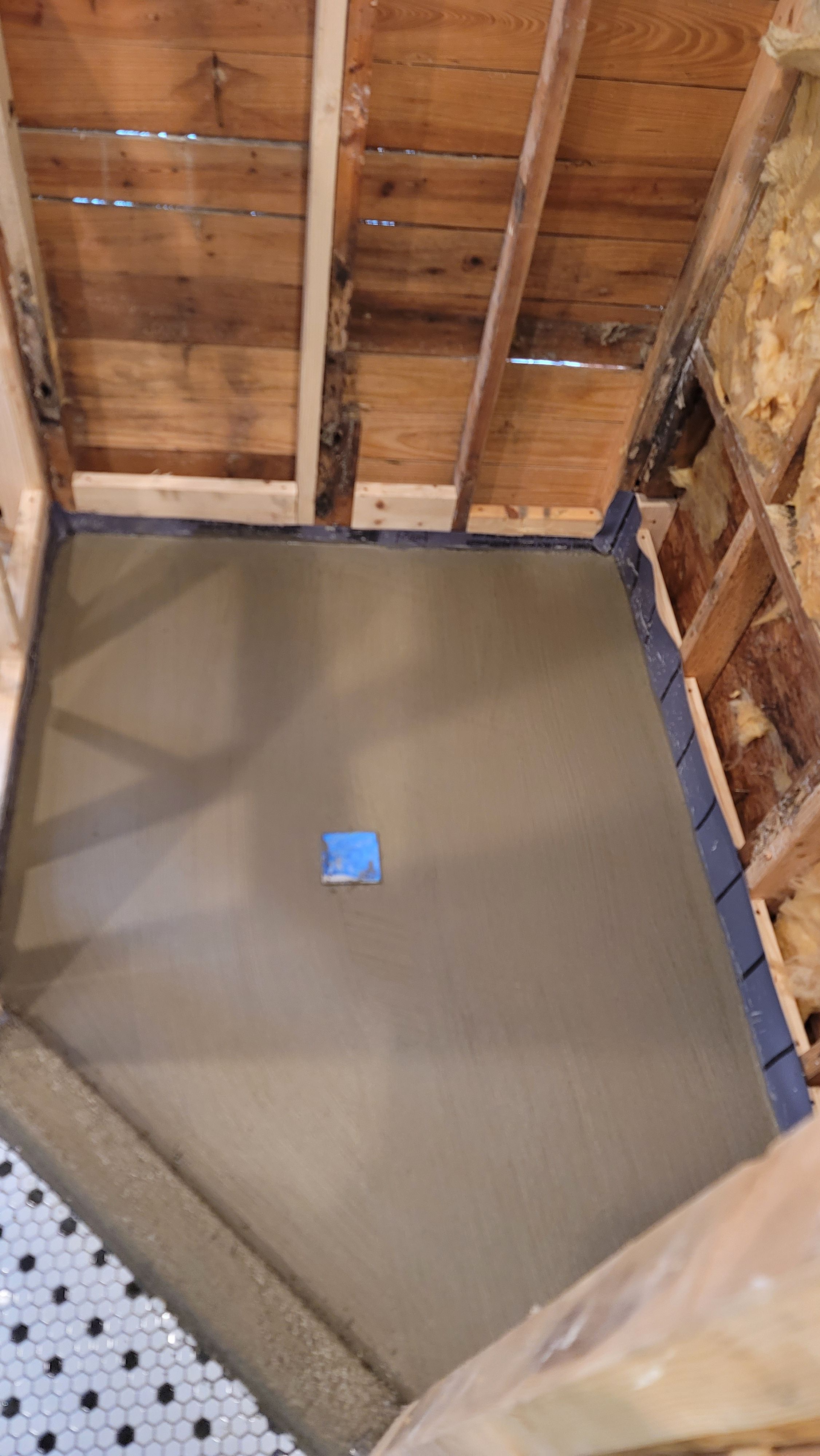 Freshly floated cement bed between floor framing