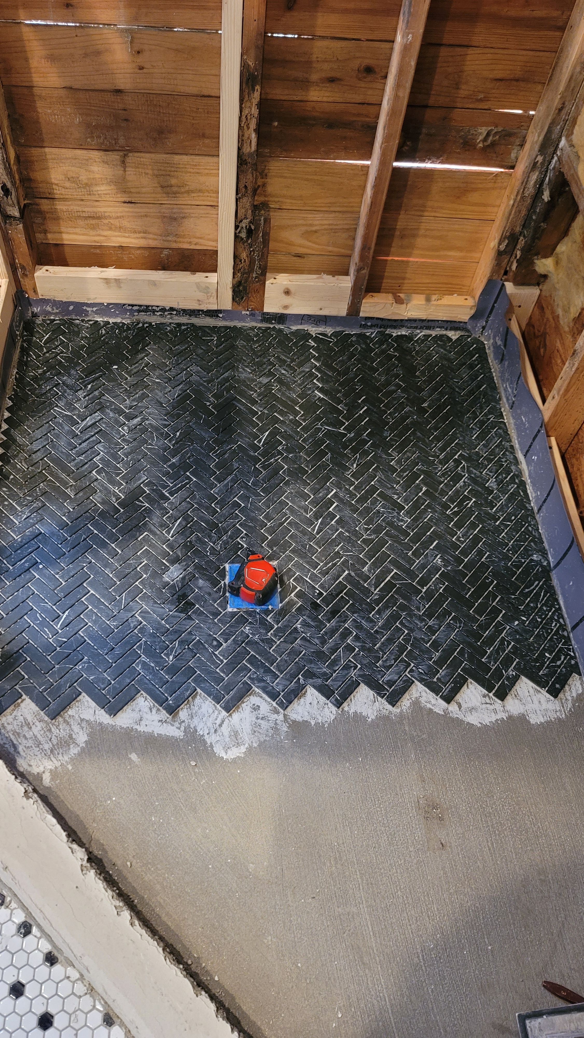 Herringbone tile floor being set, with the edge course in progress