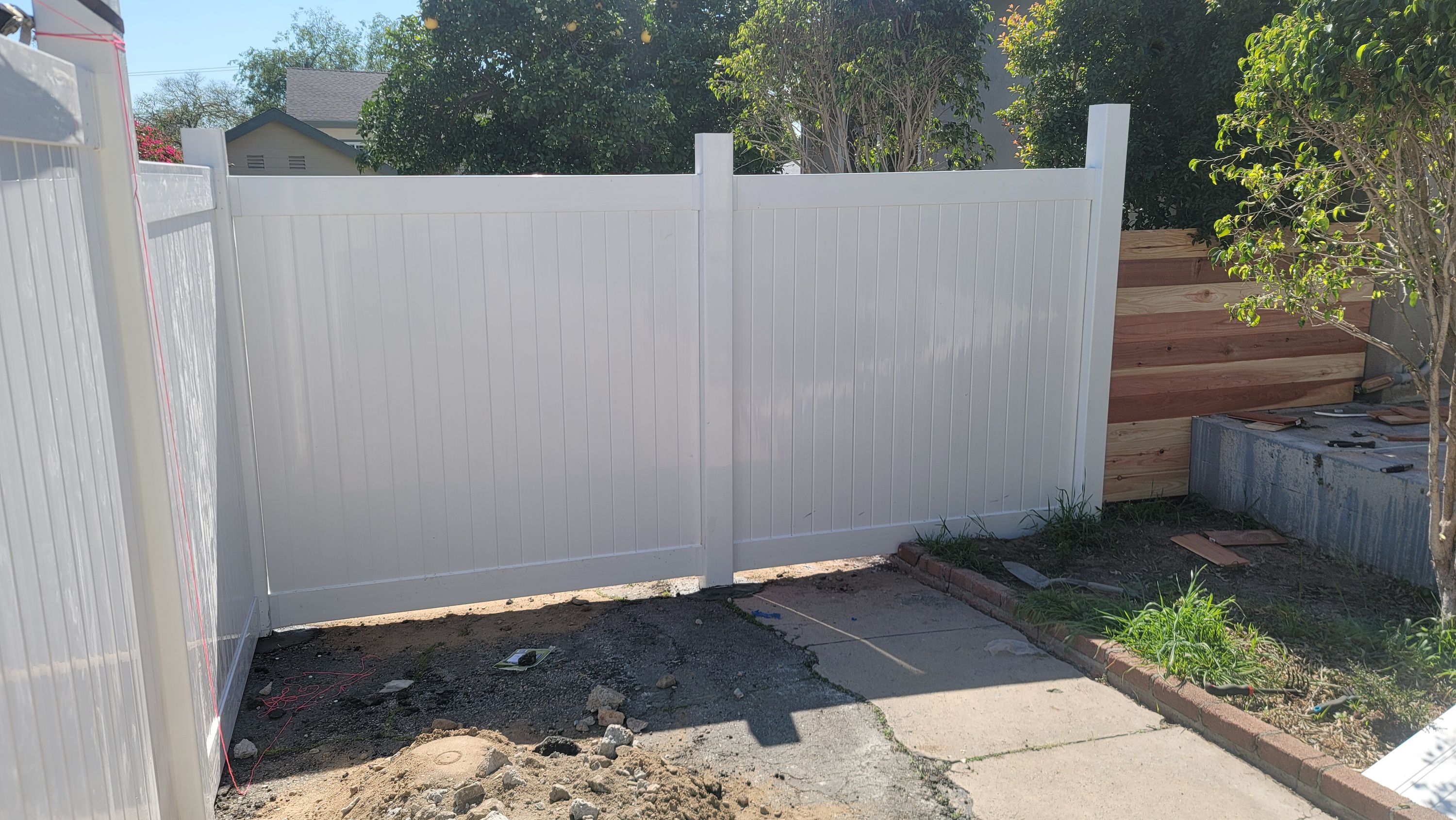 White vinyl fence and gate along a property line