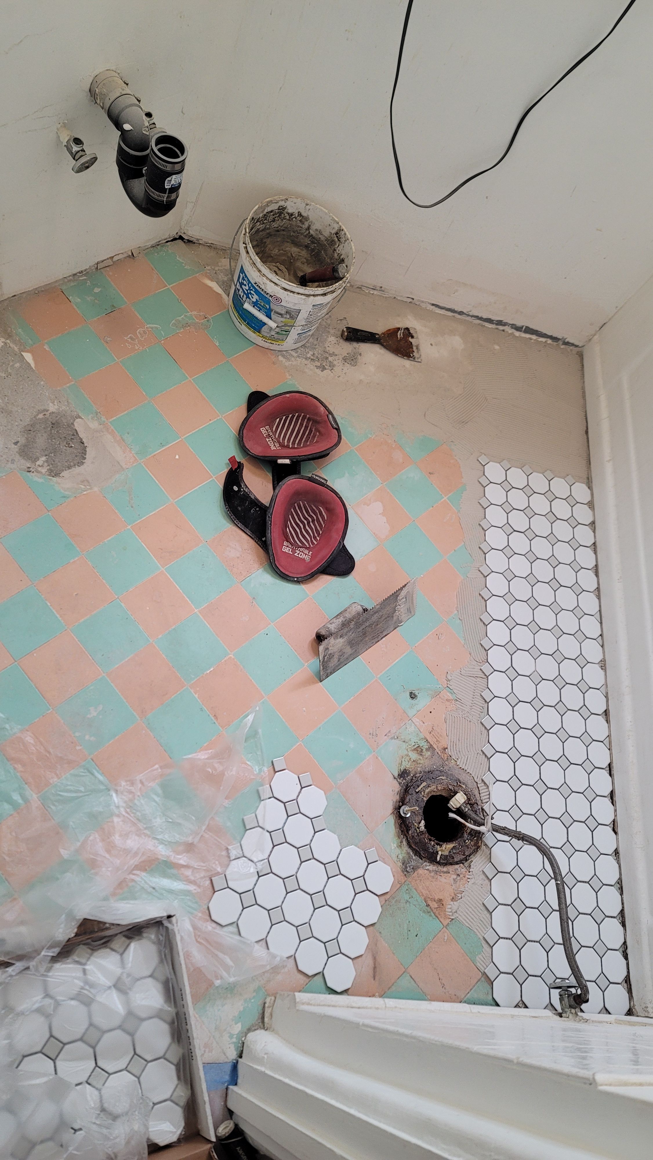 Old checkerboard tile floor being replaced with white hexagon tile