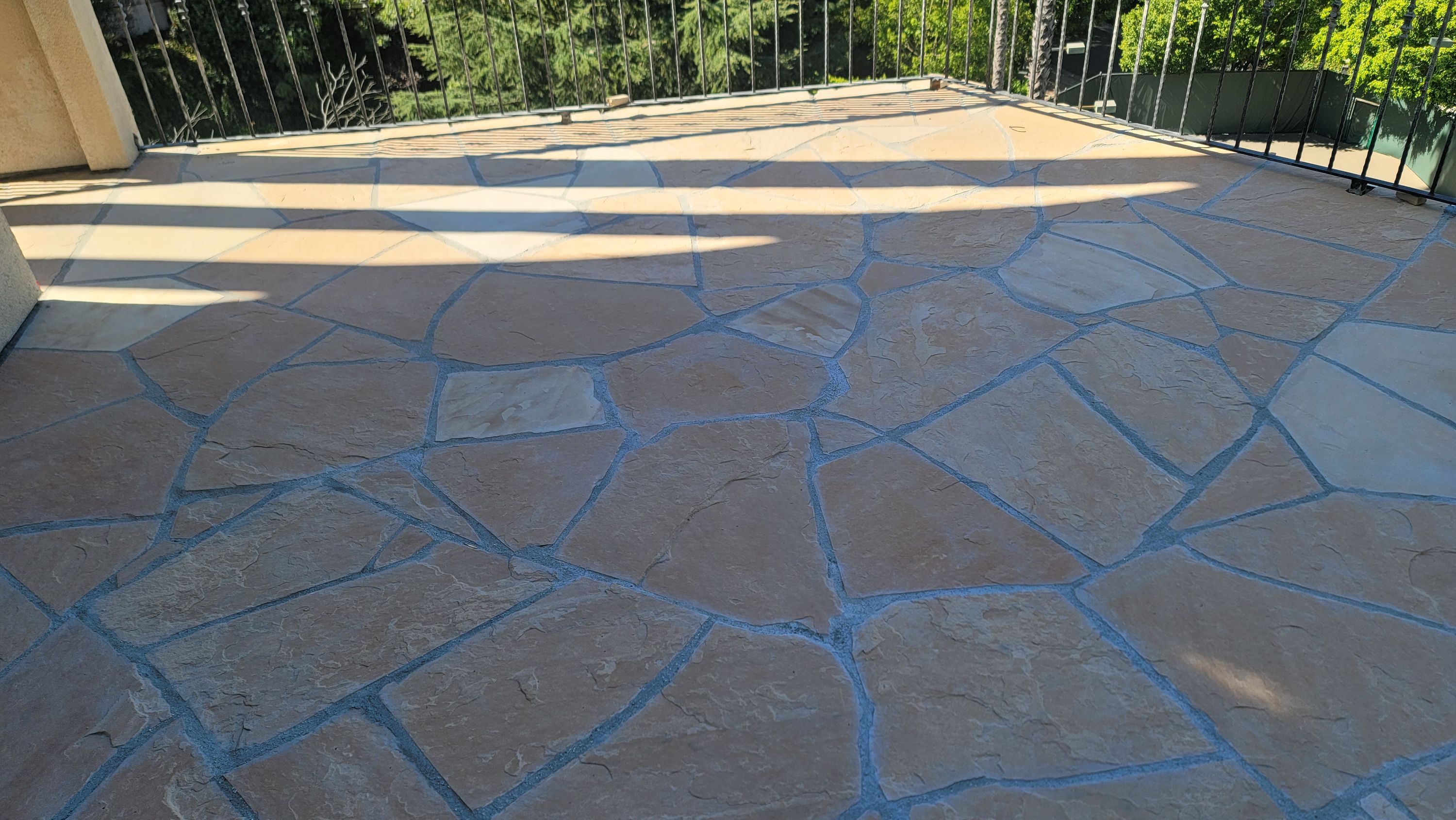 Flagstone patio with the grout joints being finished